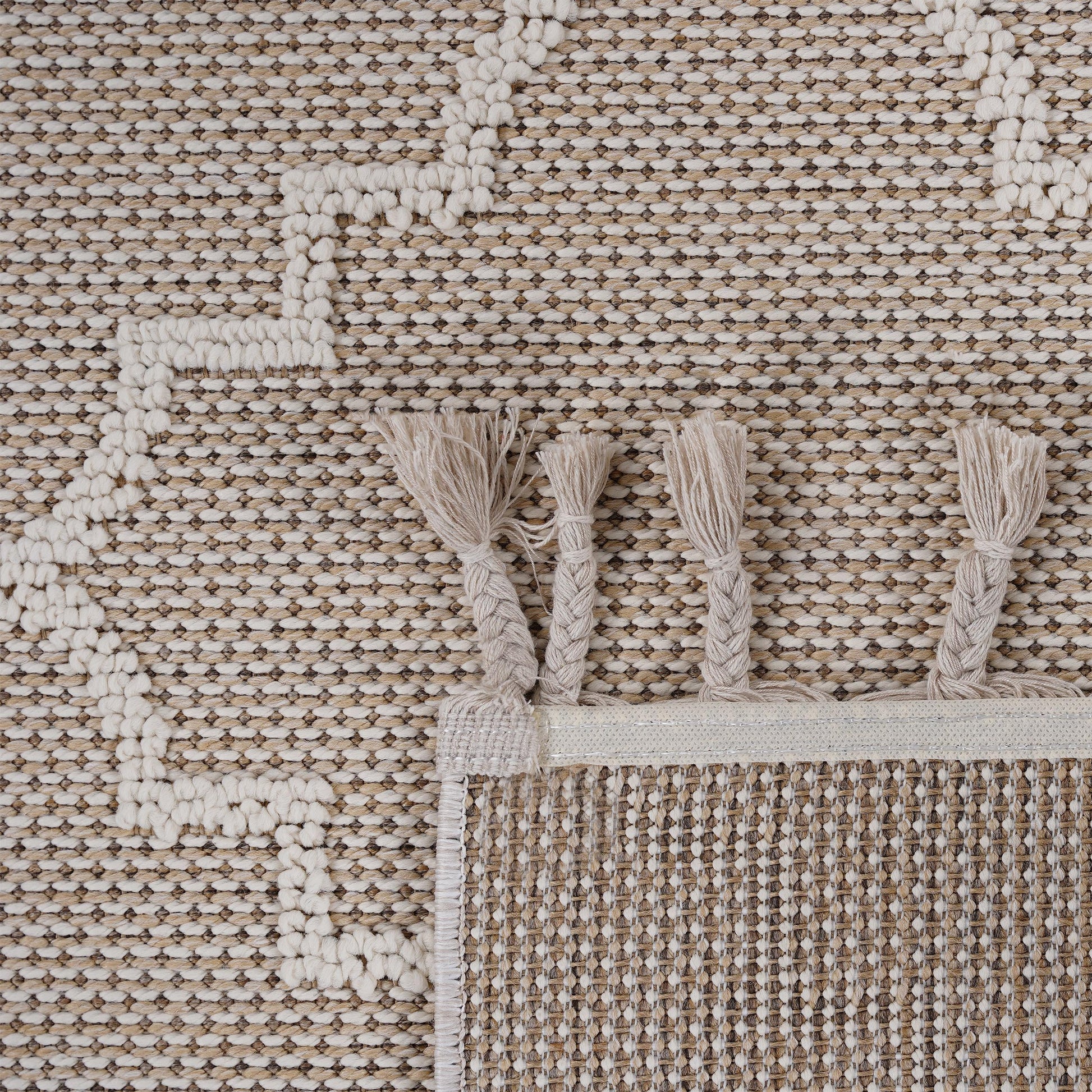Textured beige and cream woven rug with braided tassels and a geometric pattern