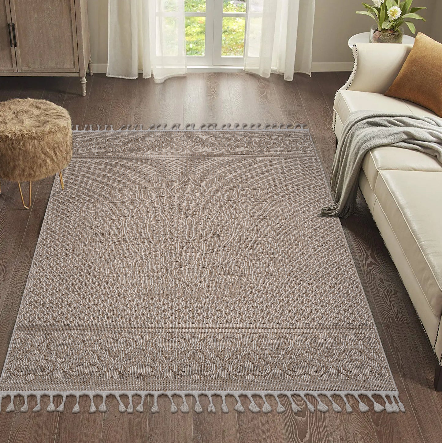 Beige and white geometric patterned area rug with tassels