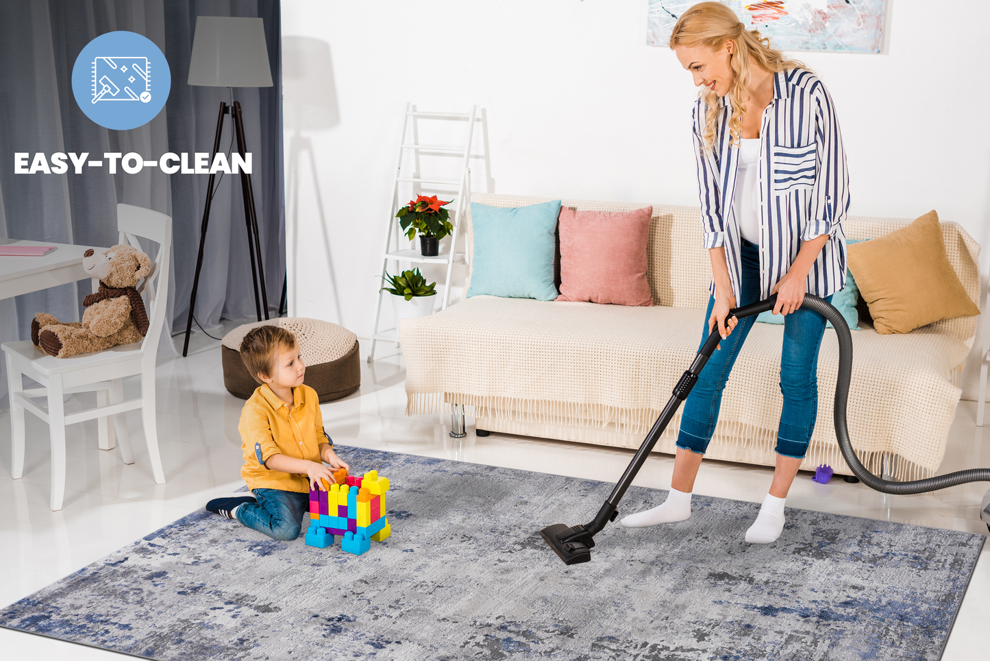 Abstract gray and blue area rug with distressed pattern shown with child playing