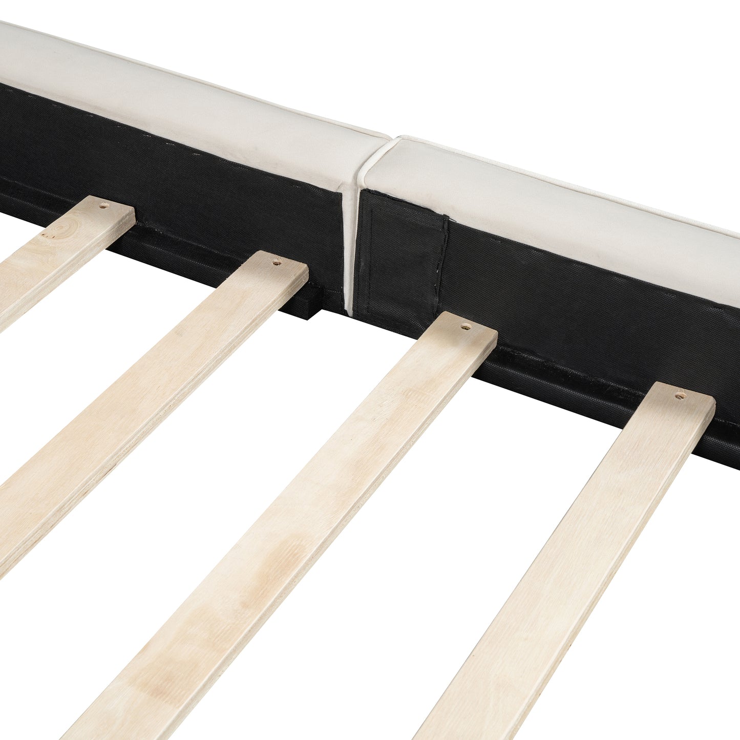 Closeup of a white upholstered bed frame edge with black fabric backing and wooden slats