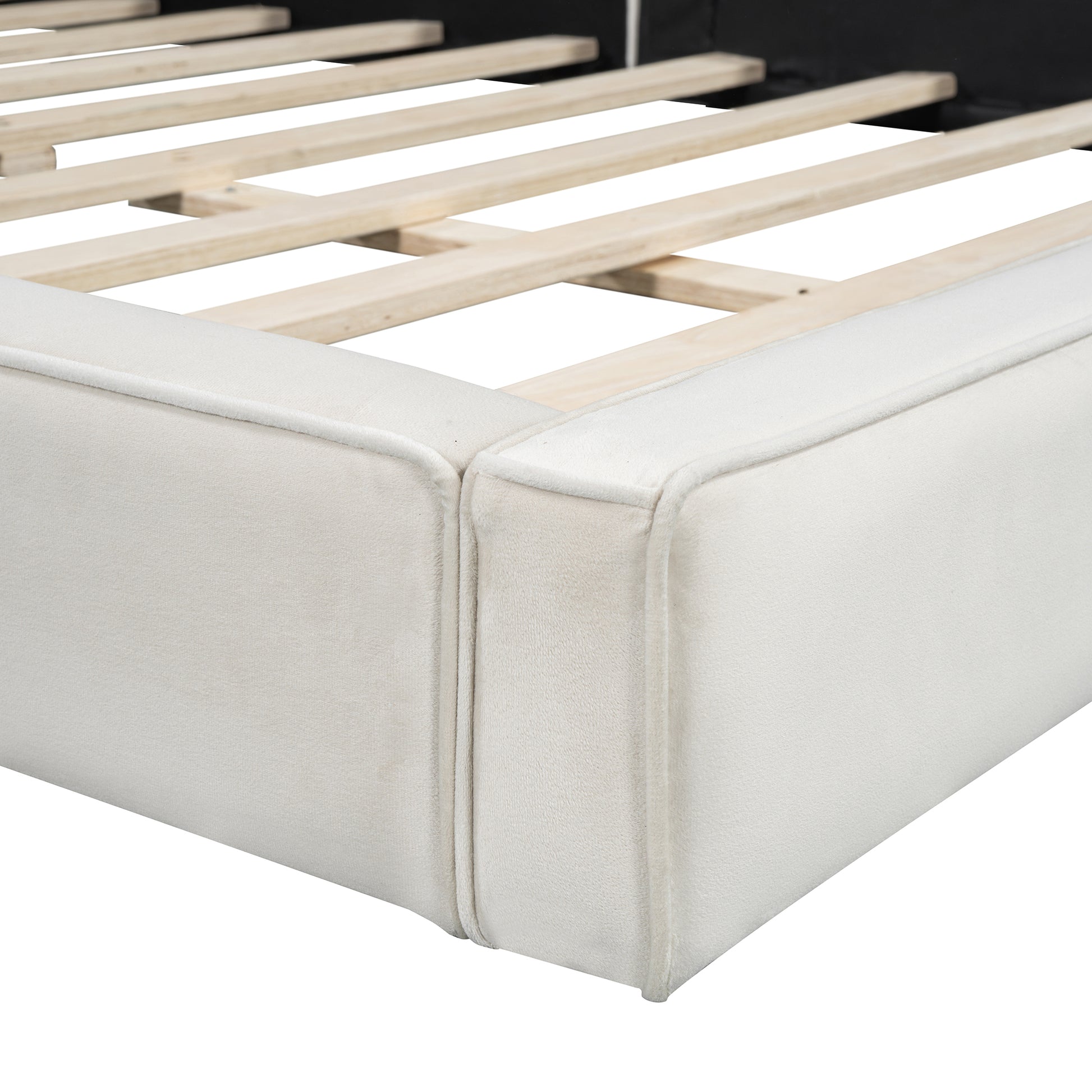 Closeup of a beige velvet bed frame with wooden slats supporting the mattress base