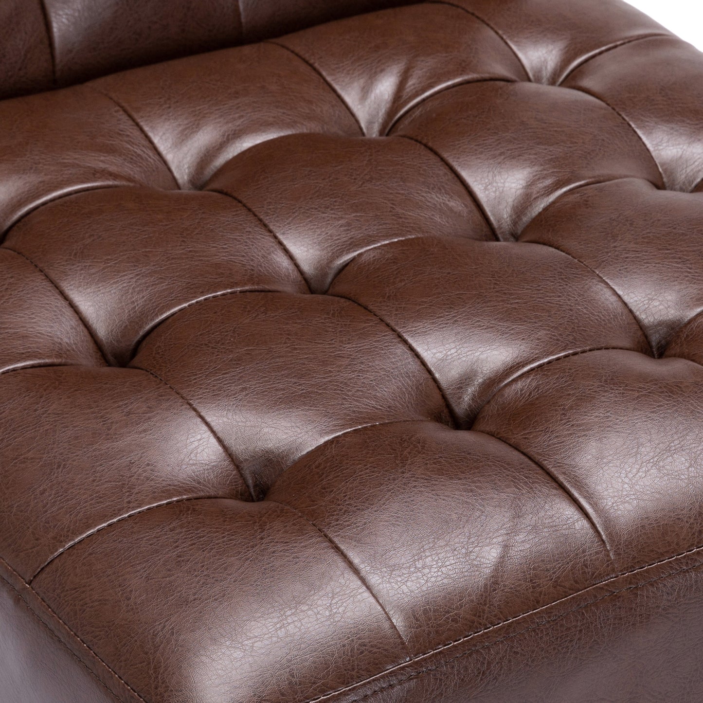 Closeup of tufted brown leather upholstery showing stitching detail on a furniture item