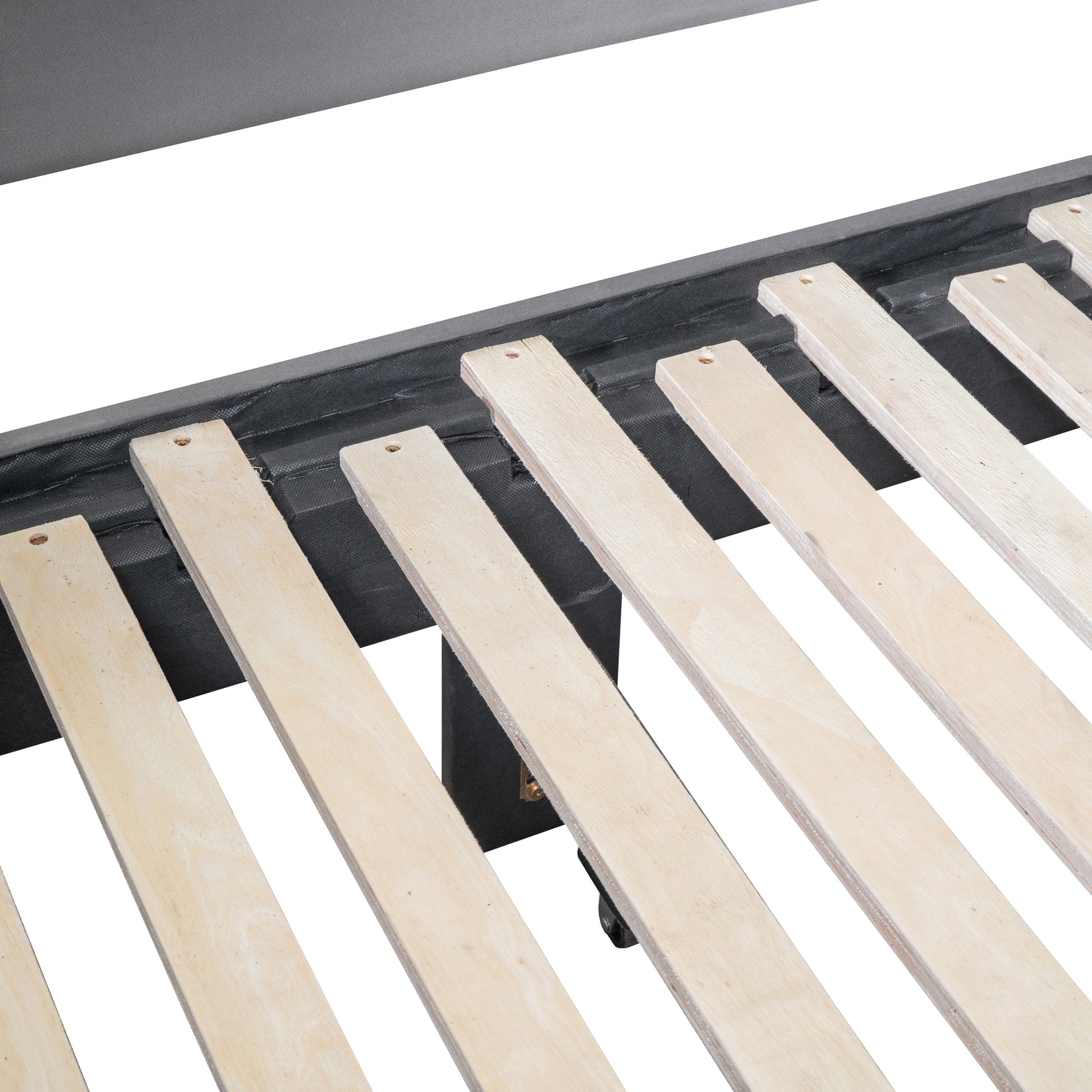 Closeup of a dark grey upholstered bed frame with natural wooden slats supporting the mattress