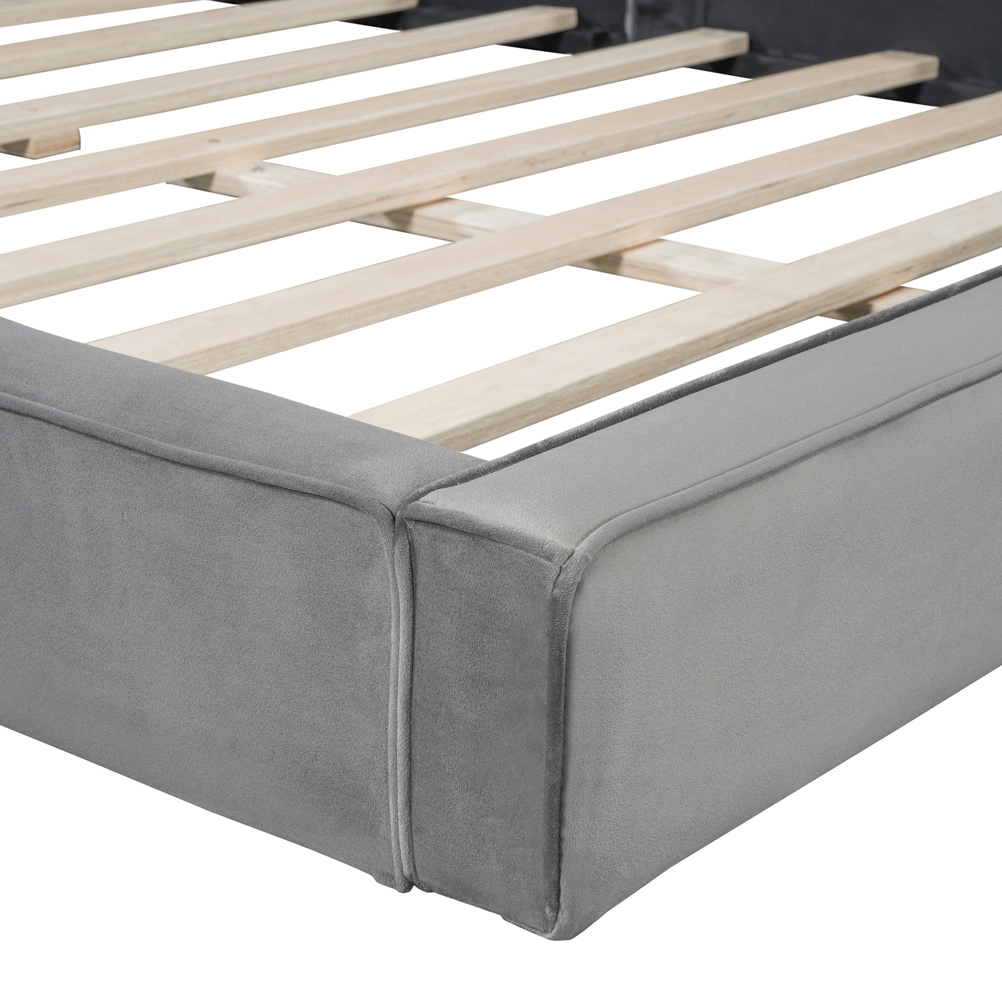 Closeup of grey velvet upholstered bed frame with wooden slats