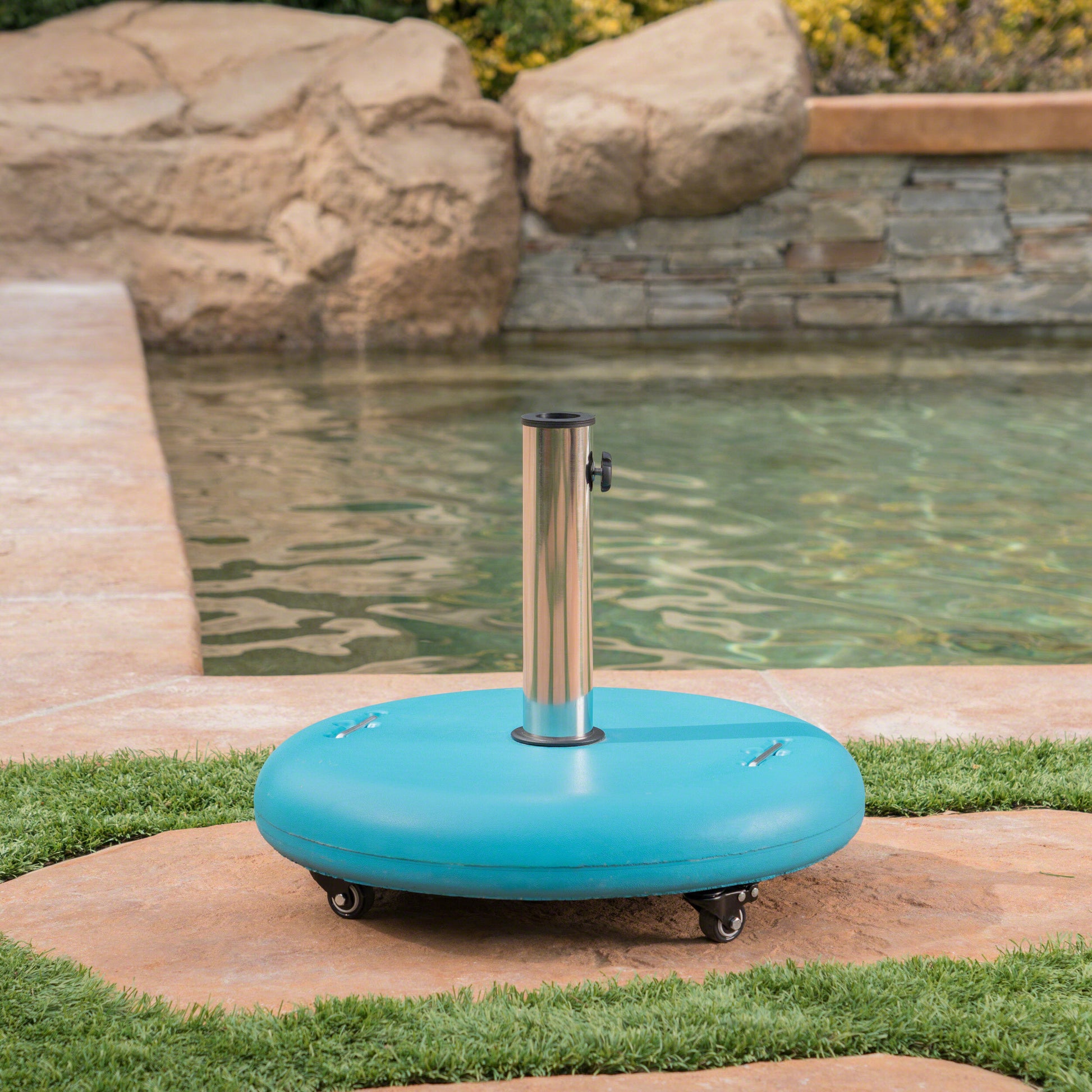 Blue rolling patio umbrella base with silver pole by a pool