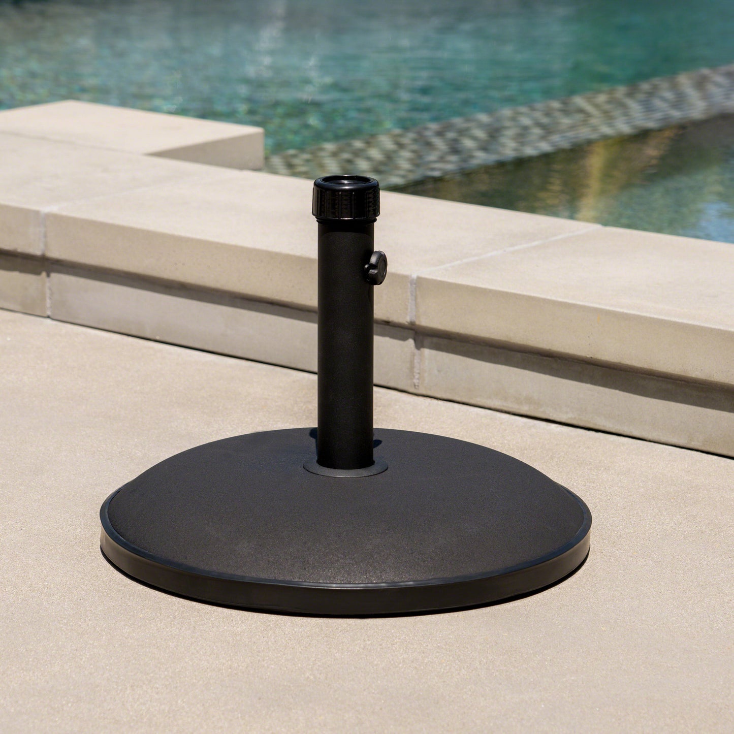 Black patio umbrella base with textured finish and adjustable knob providing stability