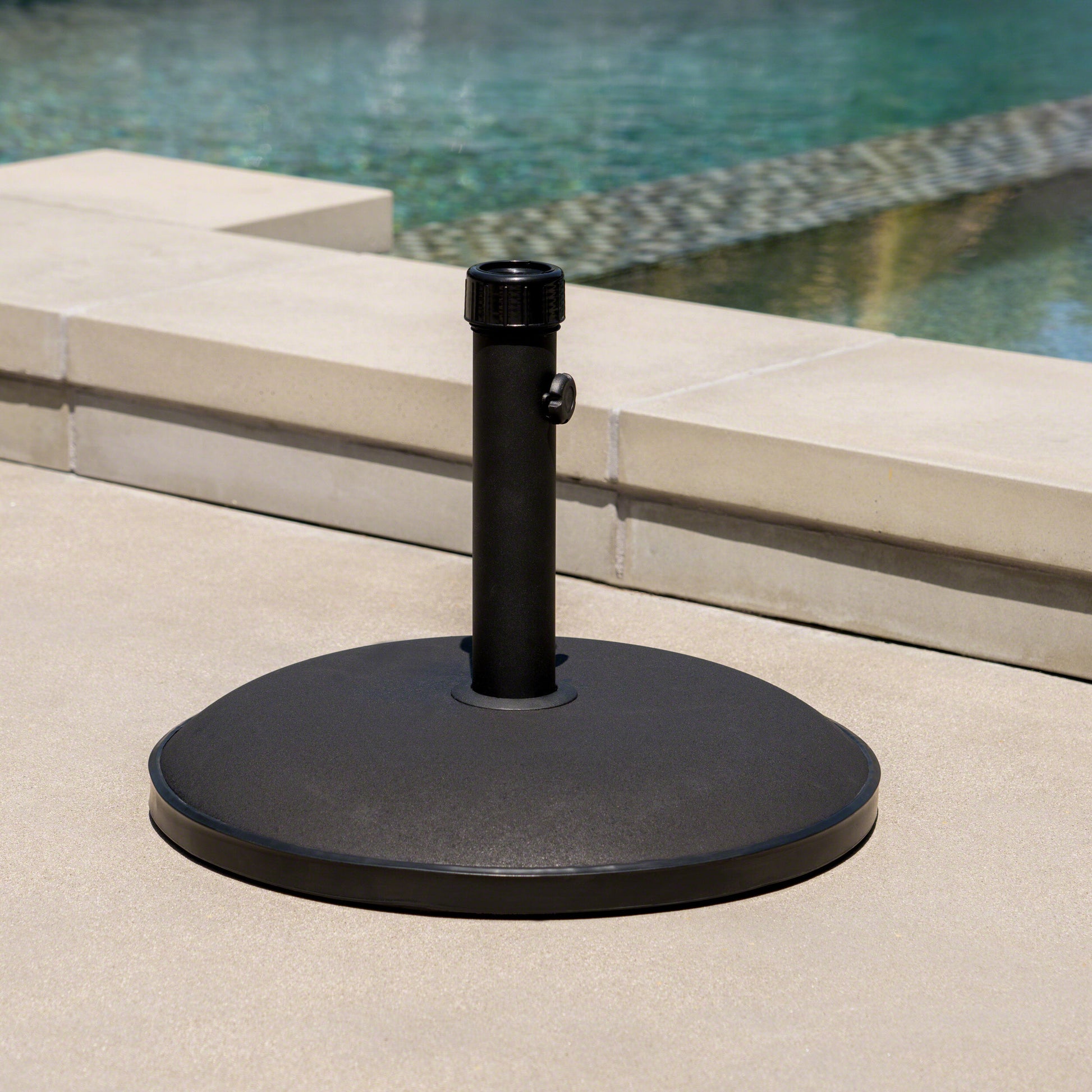 Black patio umbrella base with textured finish and adjustable knob providing stability