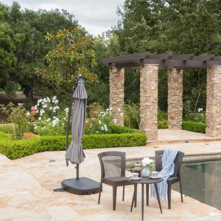 Closed grey patio umbrella with a weighted base