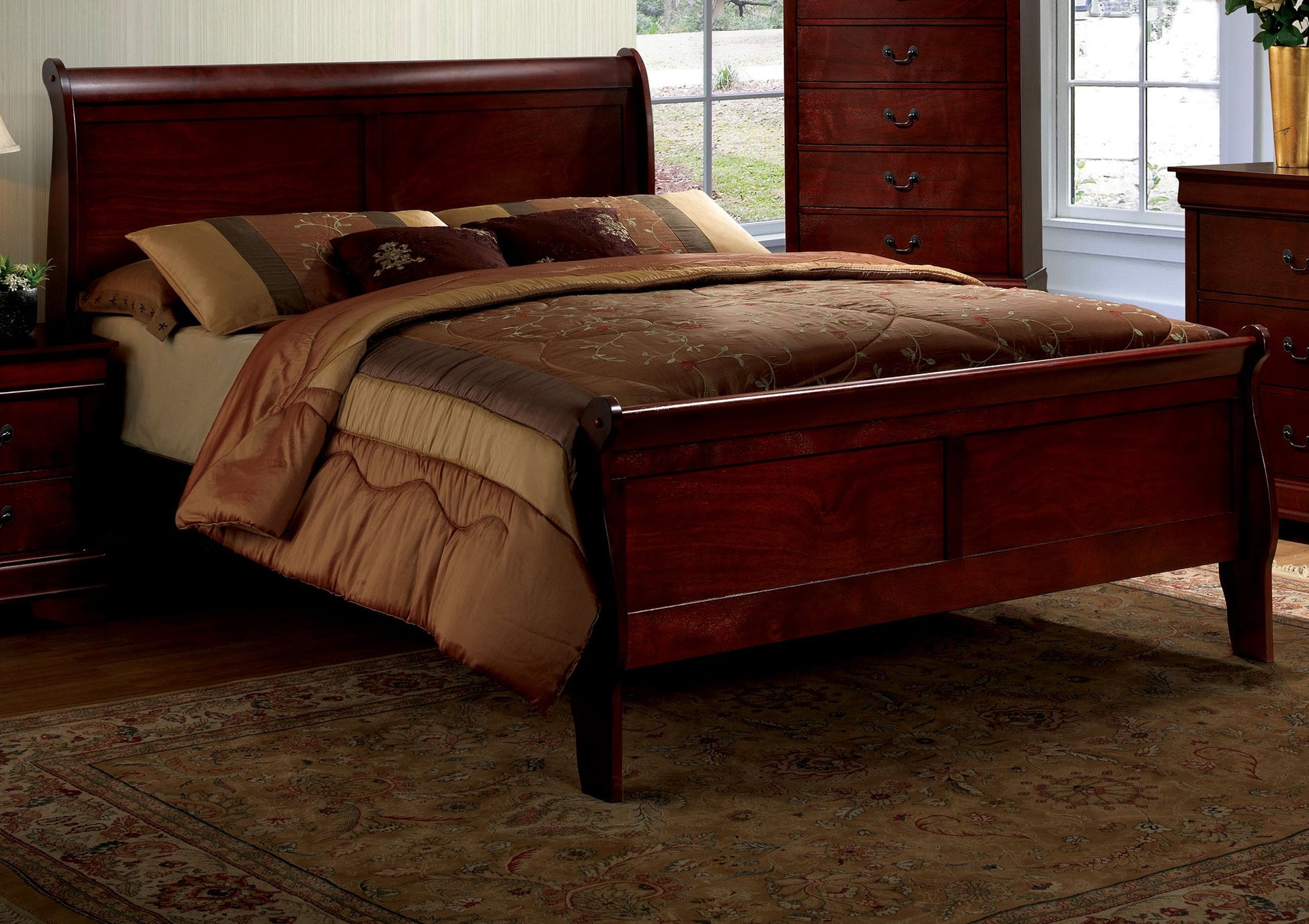 Dark cherry sleigh bed with ornate patterned comforter and pillows