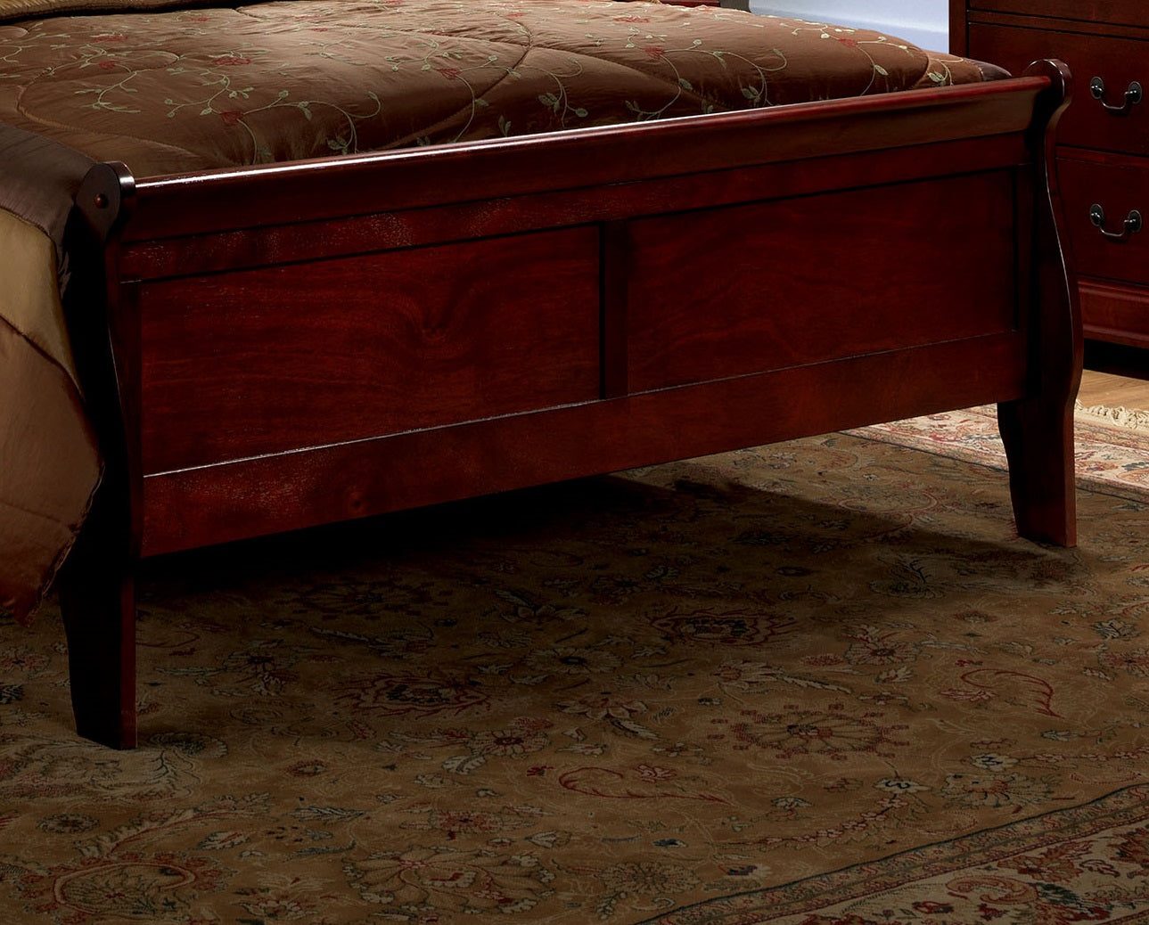 Dark cherry wood sleigh bed frame with ornate scrolling detail on headboard and footboard