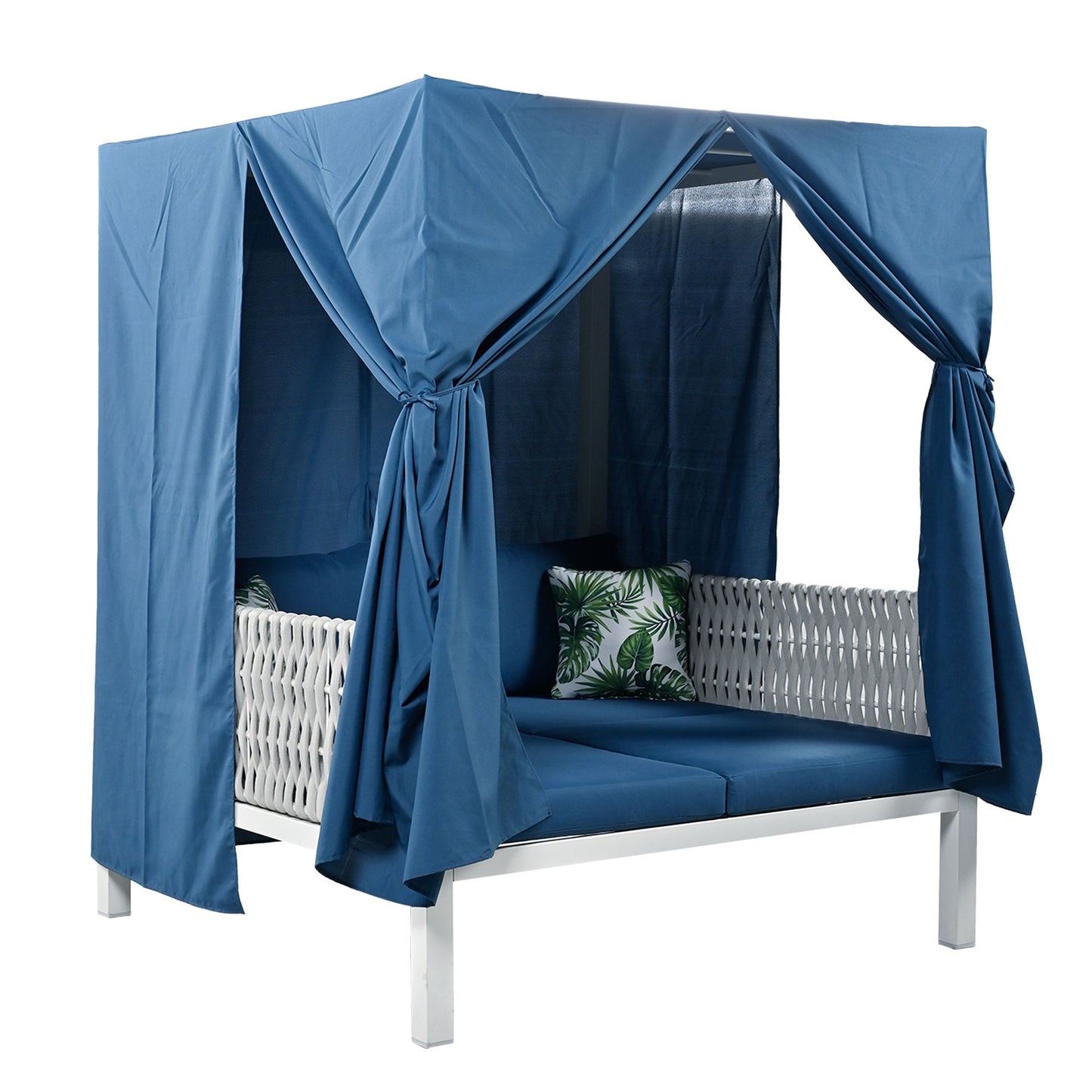 Navy blue outdoor canopy daybed with white wicker accents and tropical leaf pillows
