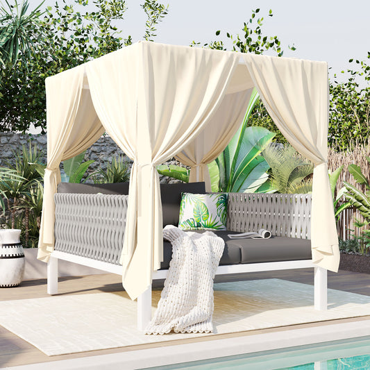 Cream canopy daybed with grey woven sides featuring a tropical leaf pillow and white throw