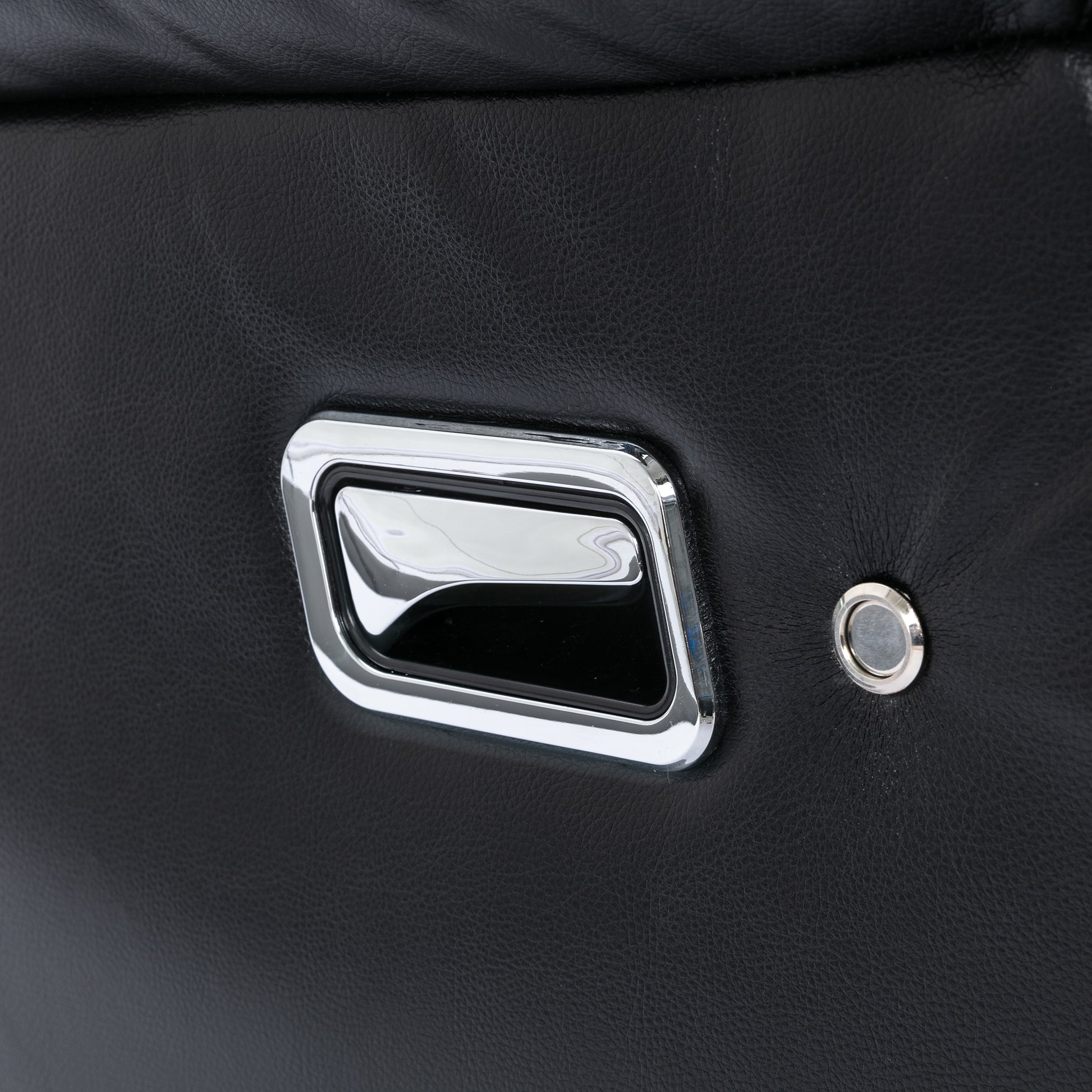 Black leather recliner handle detail with chrome accent