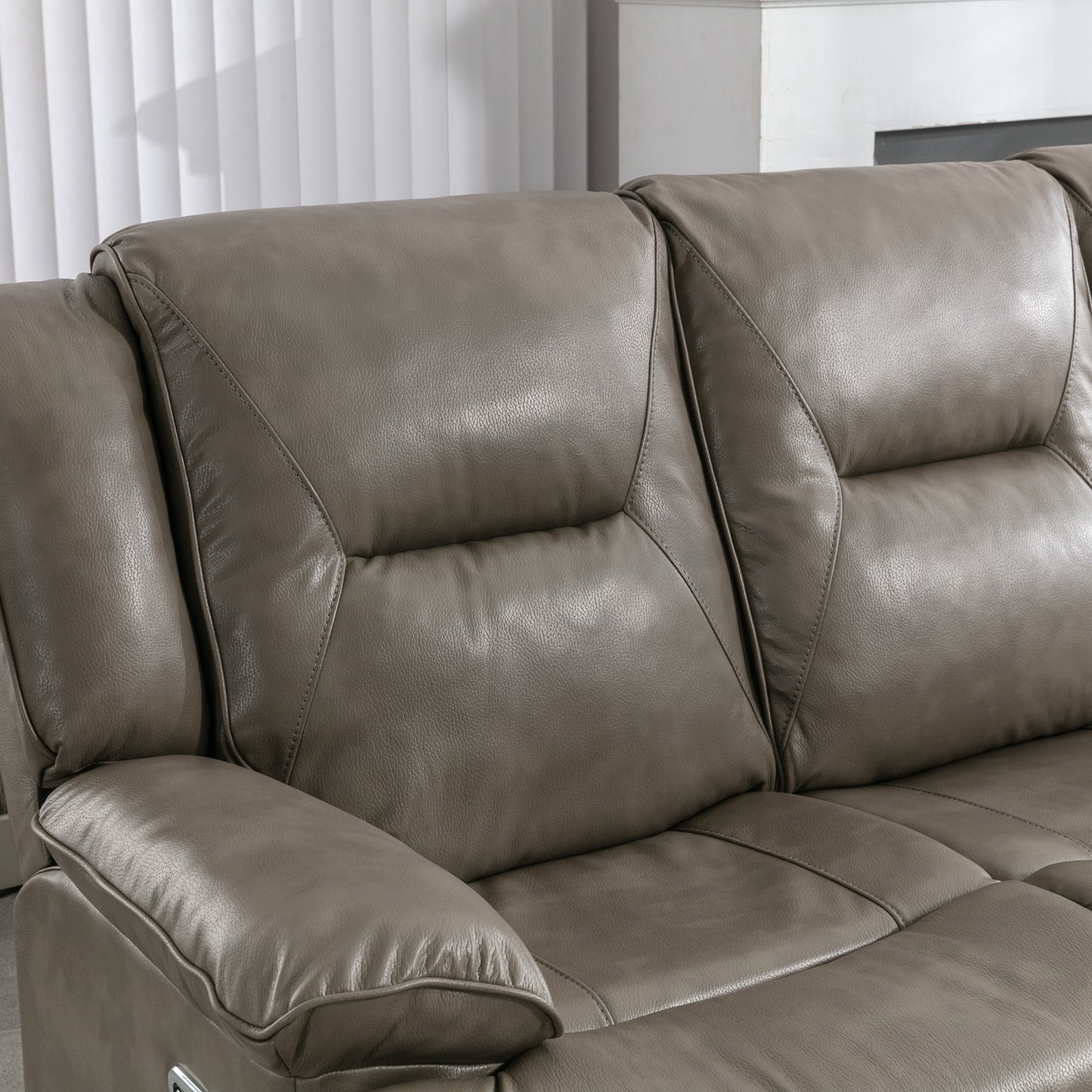 Closeup of a plush grey leather recliner sofa with diamond stitching detail