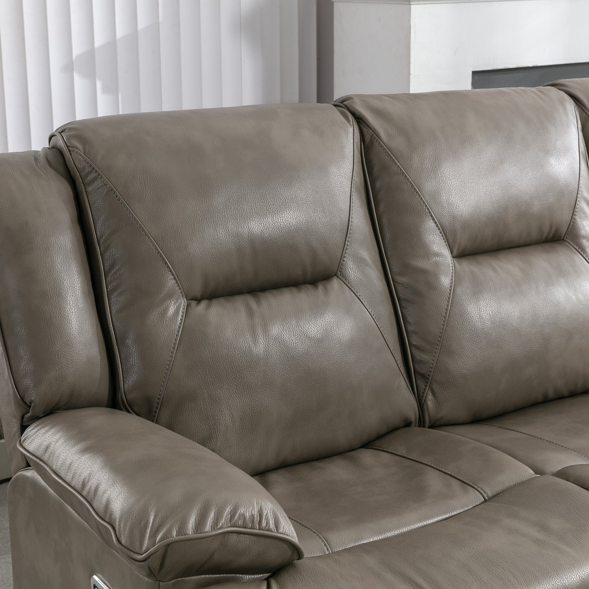 Closeup of a plush grey leather recliner sofa with diamond stitching detail