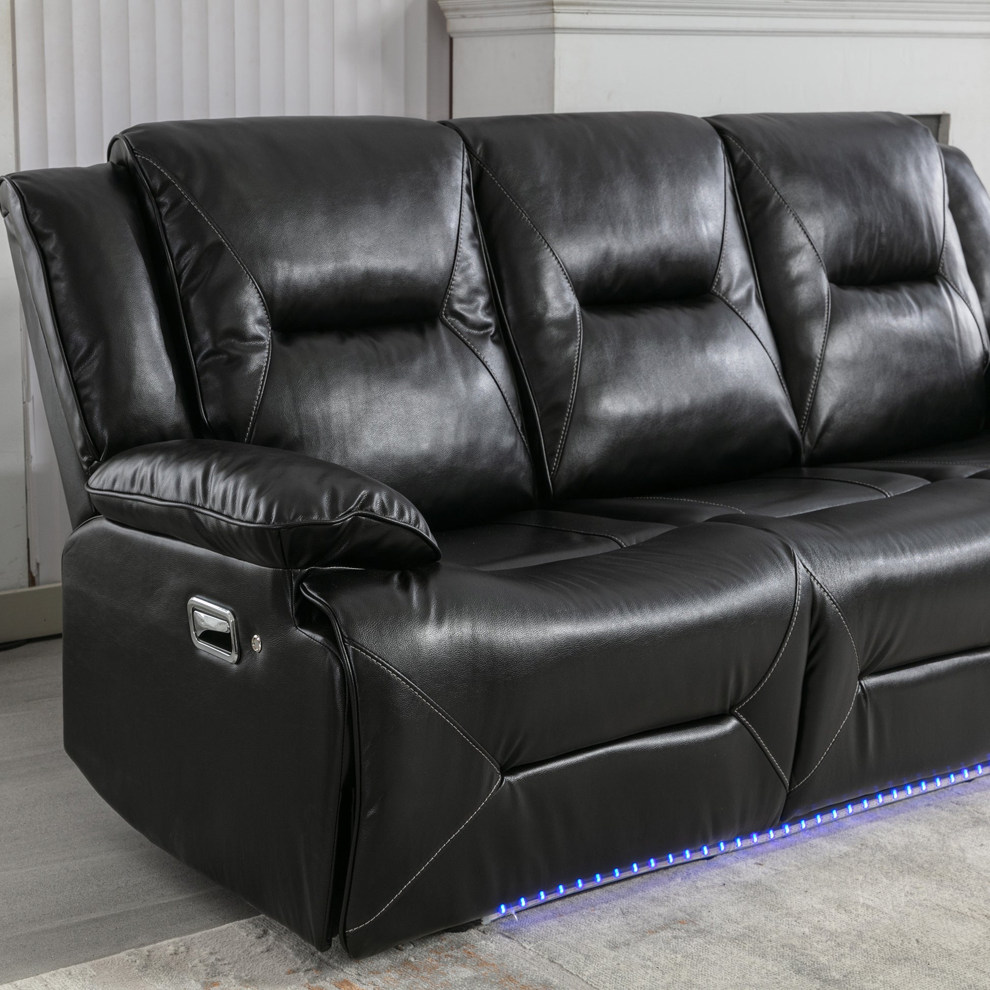 Black leather reclining sofa with modern chrome accents and blue LED base lighting