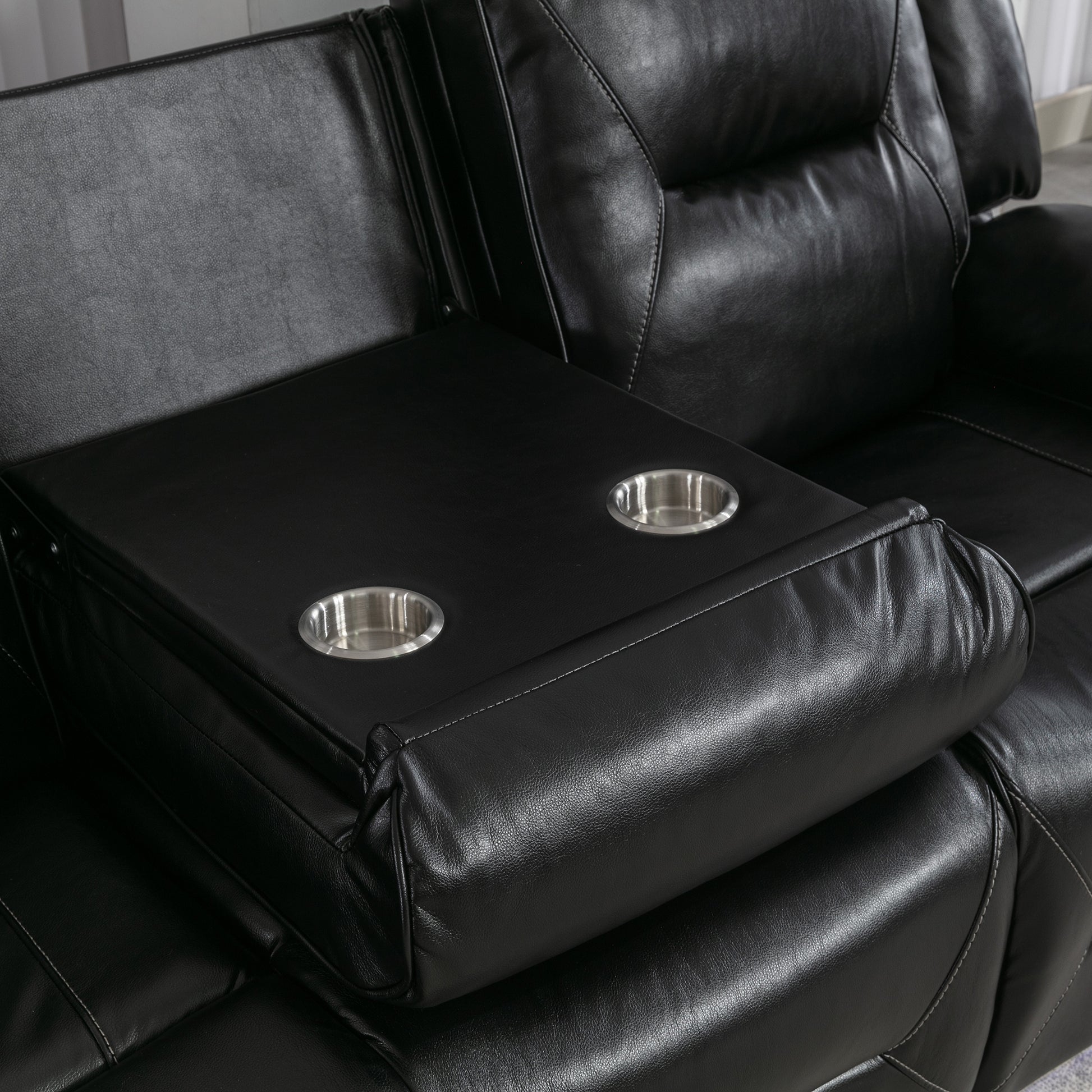 Black leather reclining sofa with builtin dual cup holders for convenience