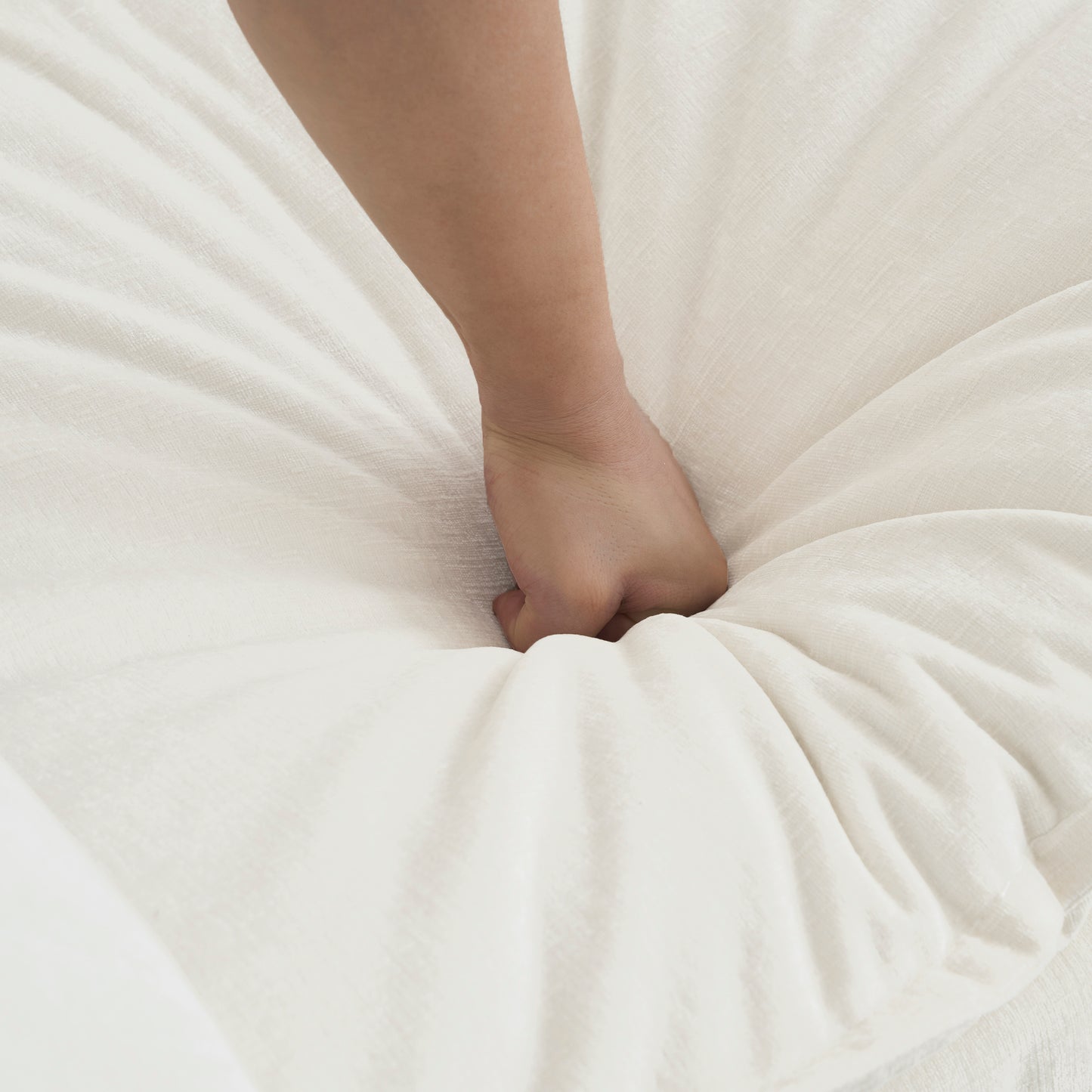 Hand pressing into soft plush white mattress demonstrating comfort and support