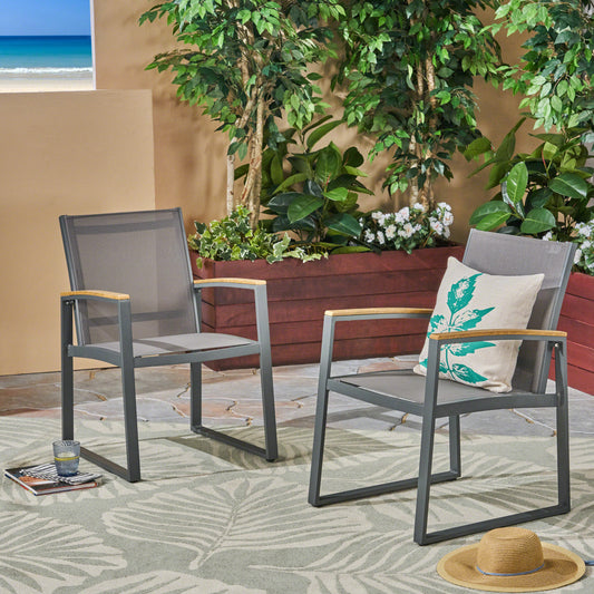 Two grey metal outdoor dining chairs with wood armrests and patterned cushions