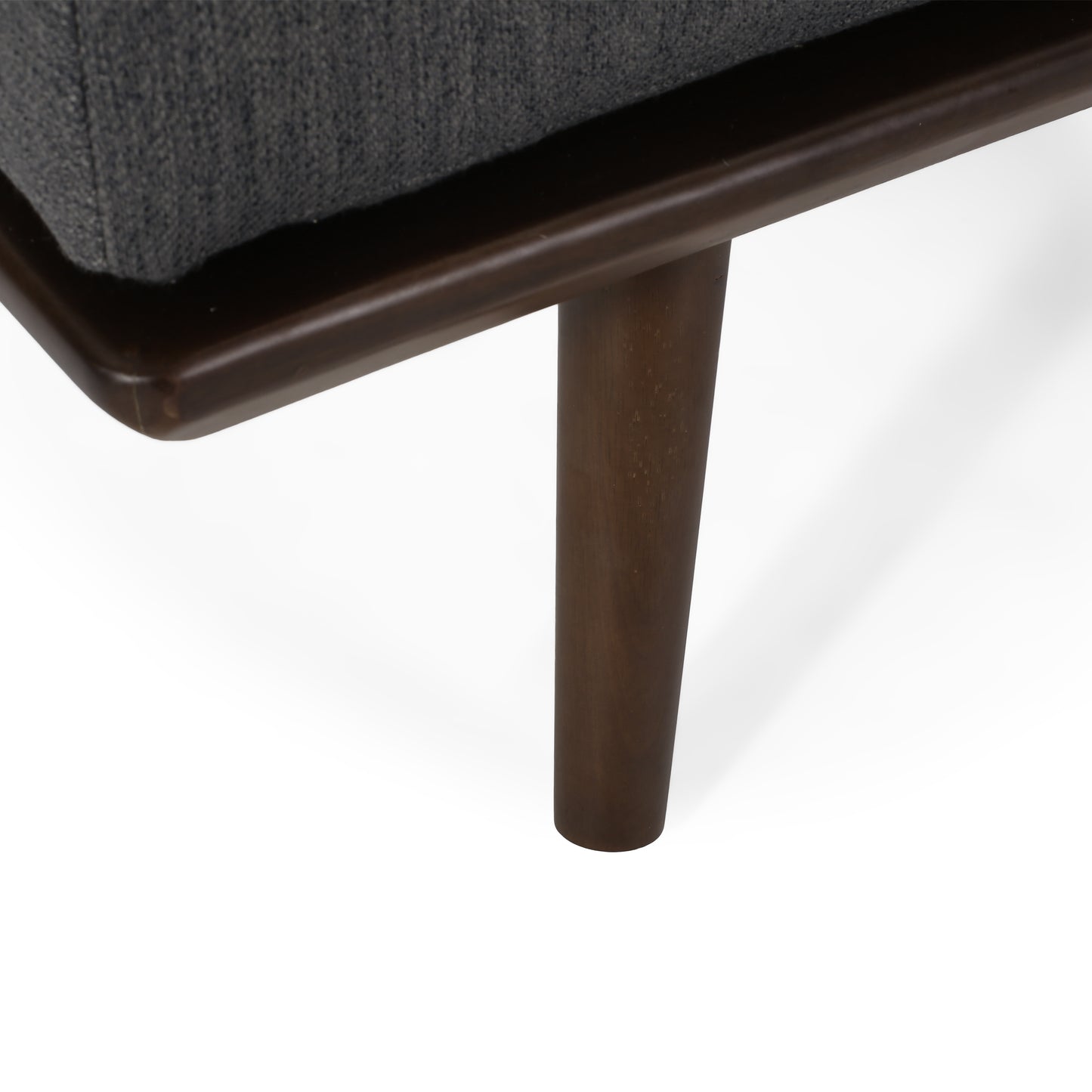 Closeup of dark wood tapered legs on a grey fabric armchair