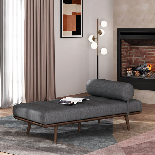 Dark grey upholstered daybed with round bolster pillow and wooden legs