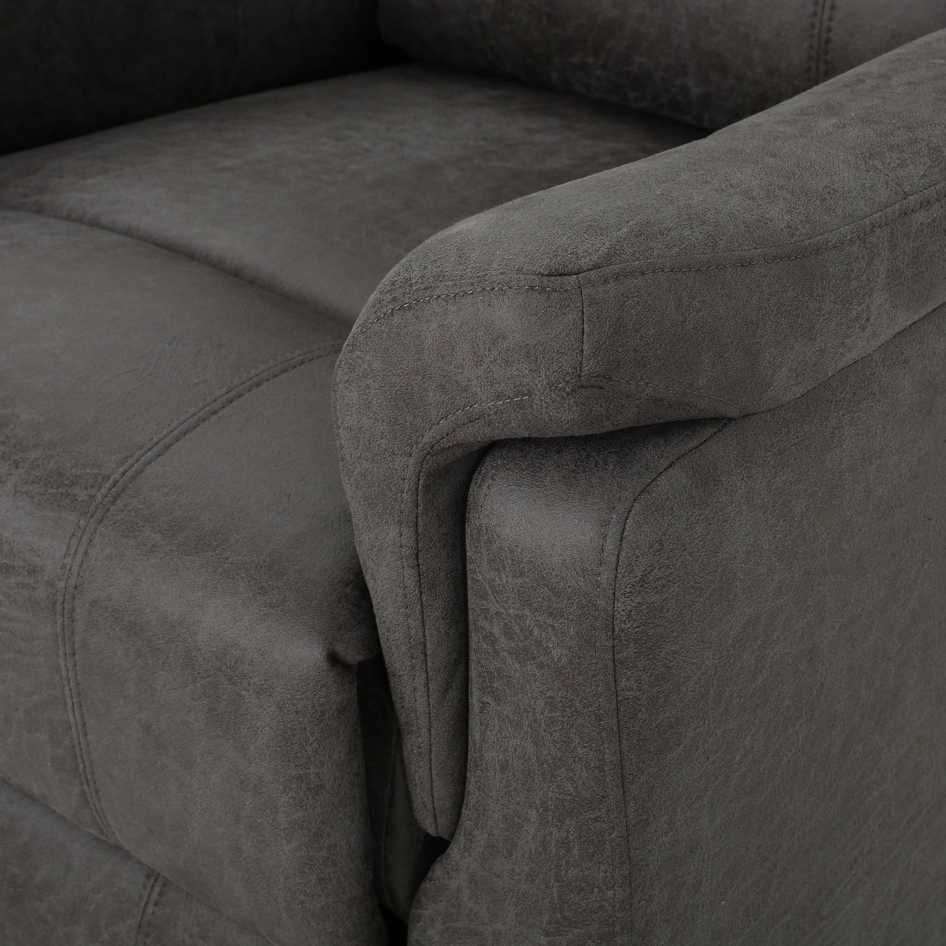 Dark gray faux leather armchair closeup showing stitched details on armrest and seat cushion