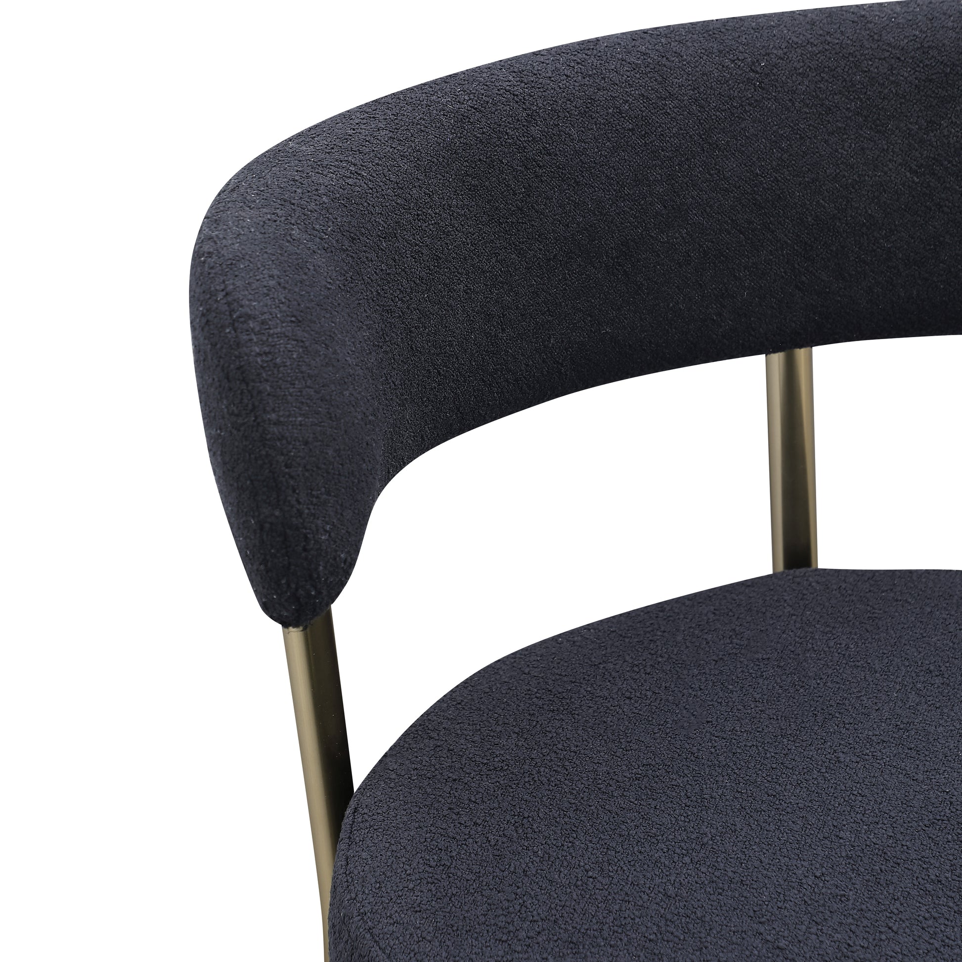 Closeup of dark grey textured boucle fabric armchair with gold metal legs