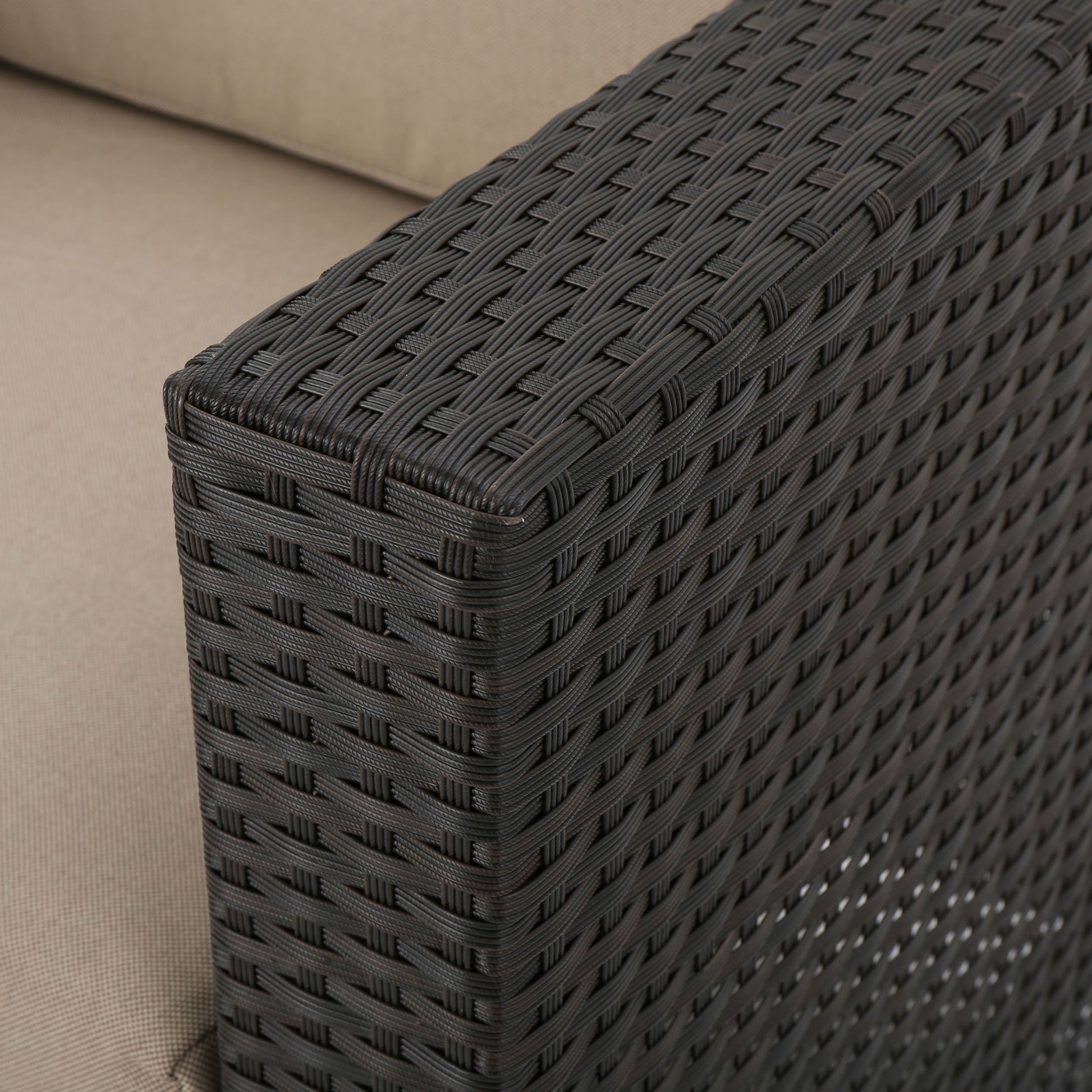 Dark brown wicker armrest detail with beige cushion fabric