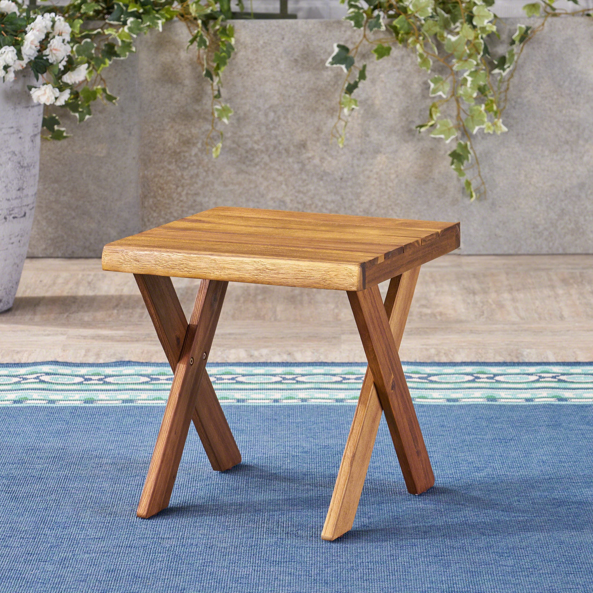 Wooden patio side table with a slat top and crisscross legs