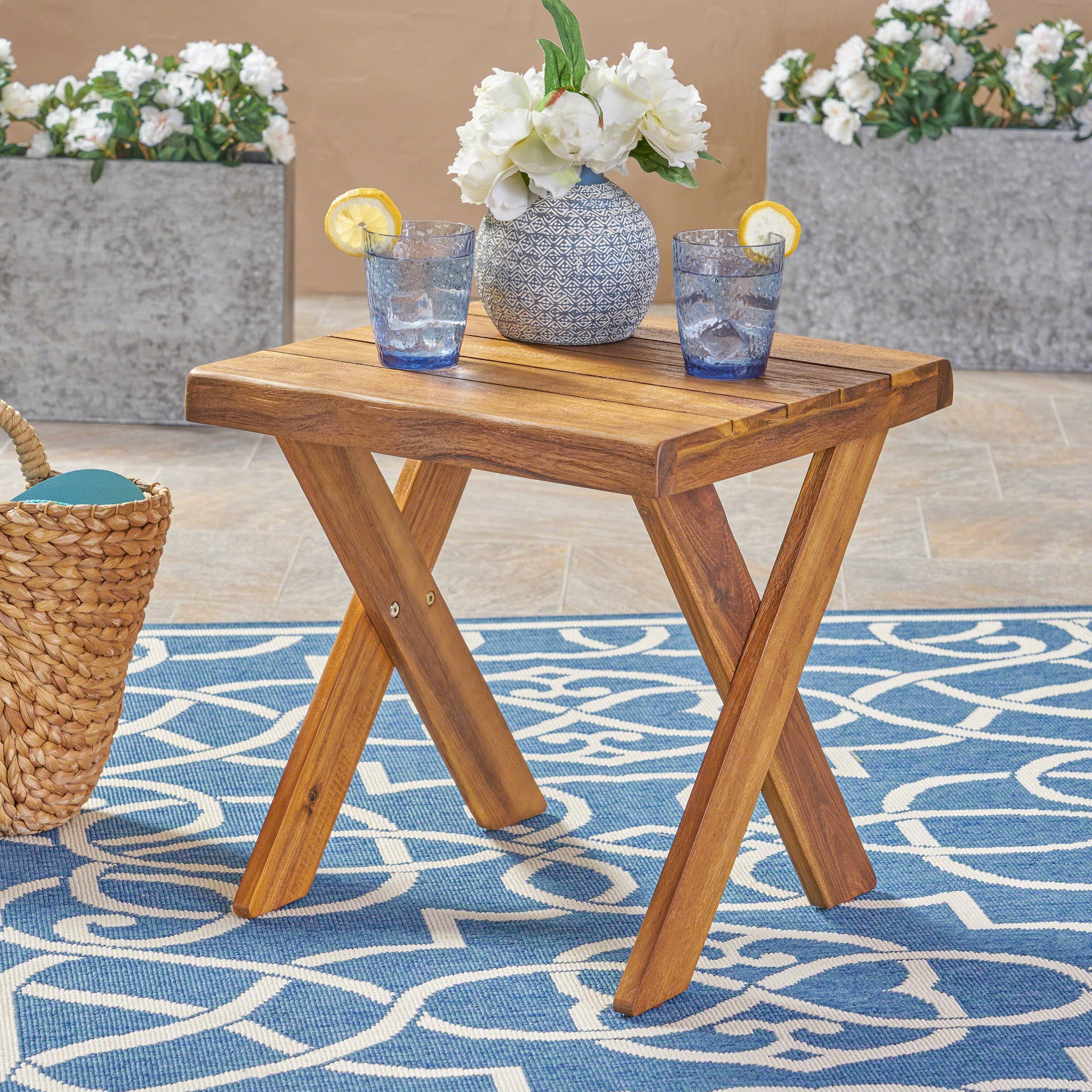 Compact wooden side table with Xshaped legs perfect for outdoor patio use