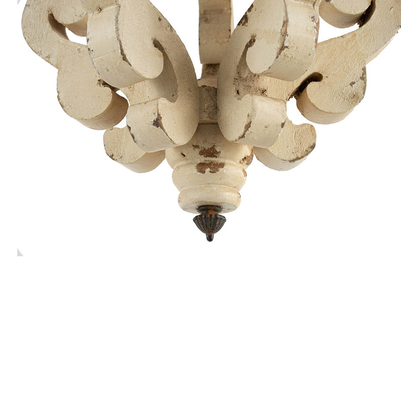 Ornate creamcolored chandelier detail with distressed finish and dark finial