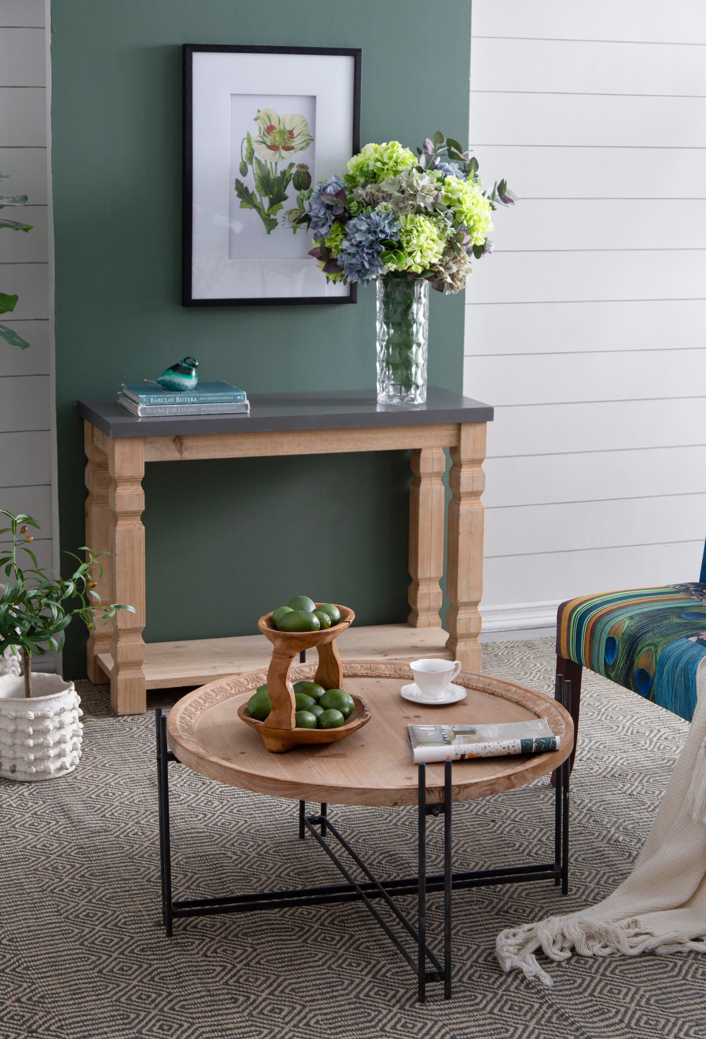 Elegant teal and green glass bird figurine perched on stacked books on a console table
