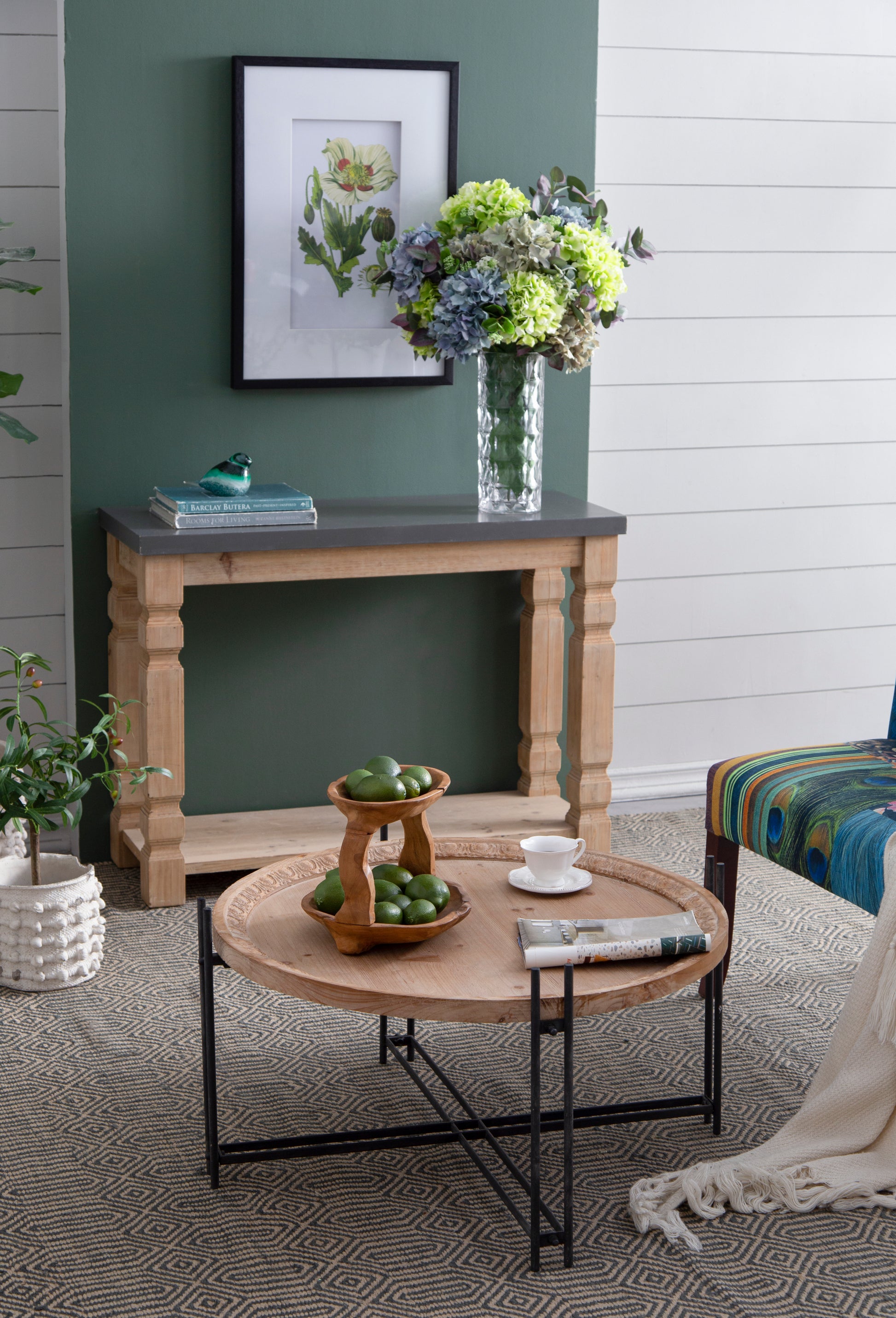 Elegant teal and green glass bird figurine perched on stacked books on a console table