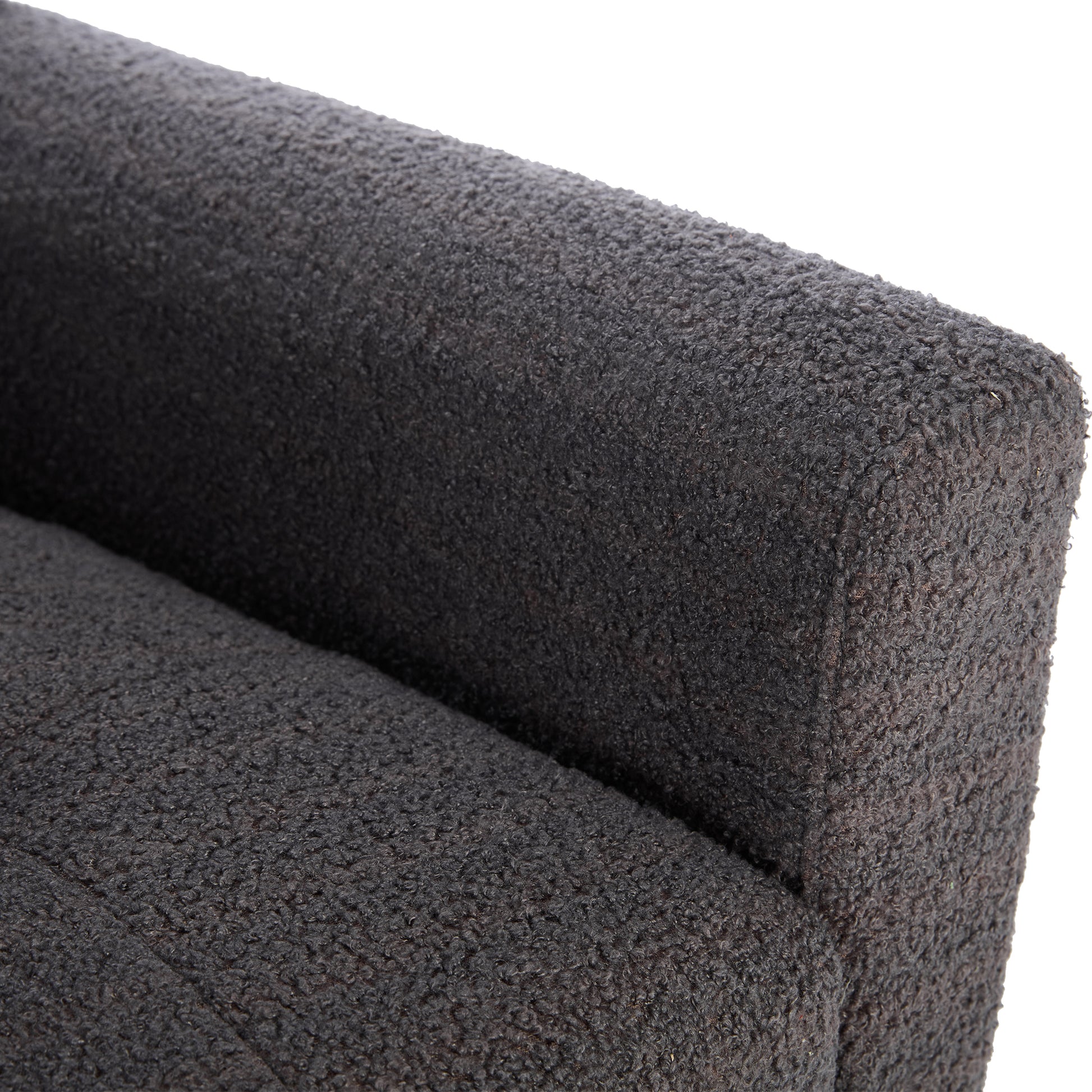 Closeup of textured dark grey boucle fabric on a modern armchairs armrest