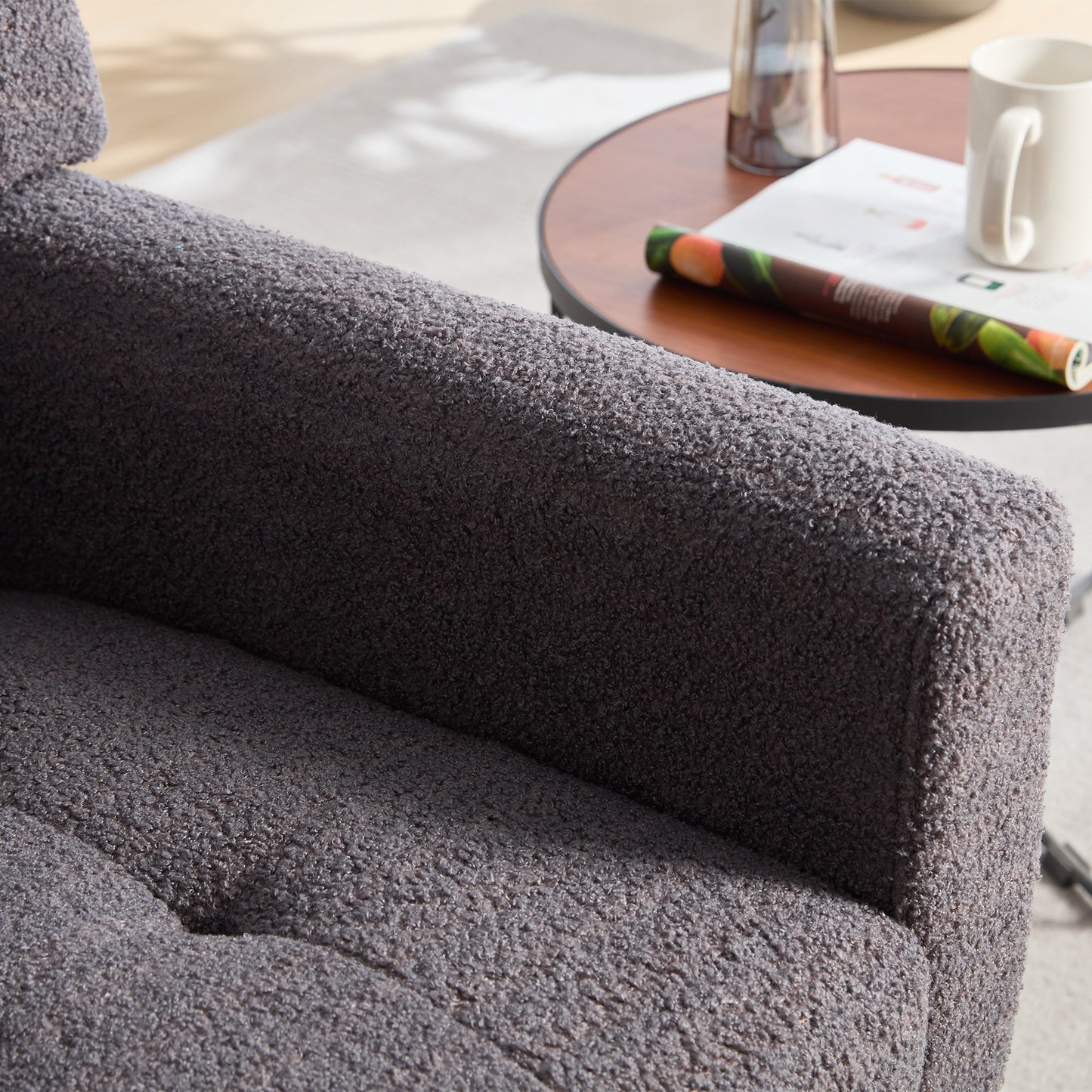 Close up of dark gray boucle fabric armchair armrest for cozy living room seating