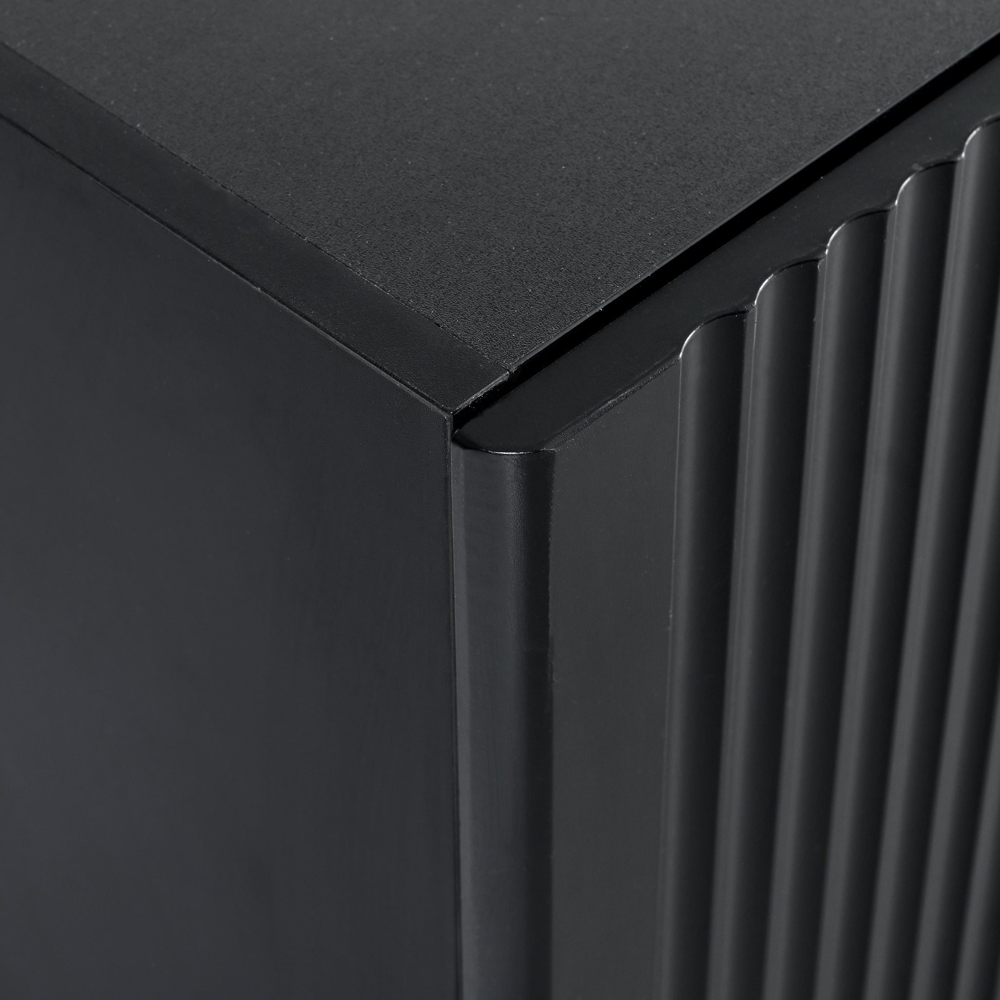 Dark grey ribbed cabinet corner featuring fluted side panel detail
