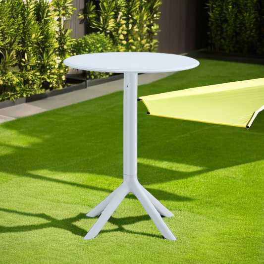 White round outdoor bistro table with a textured top and a fourlegged base on artificial grass