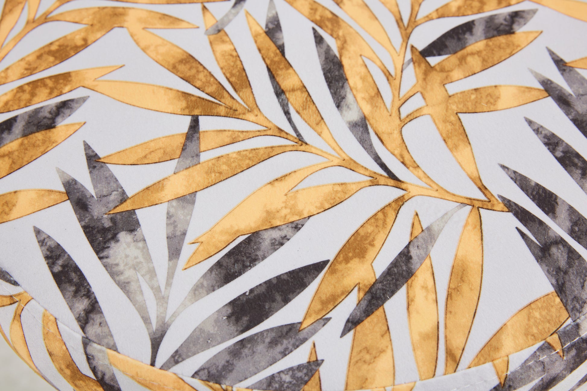 Golden palm leaf pattern on a white fabric textile