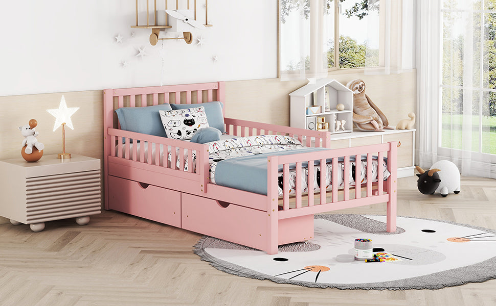 Pink wooden toddler bed with safety rails and storage drawers