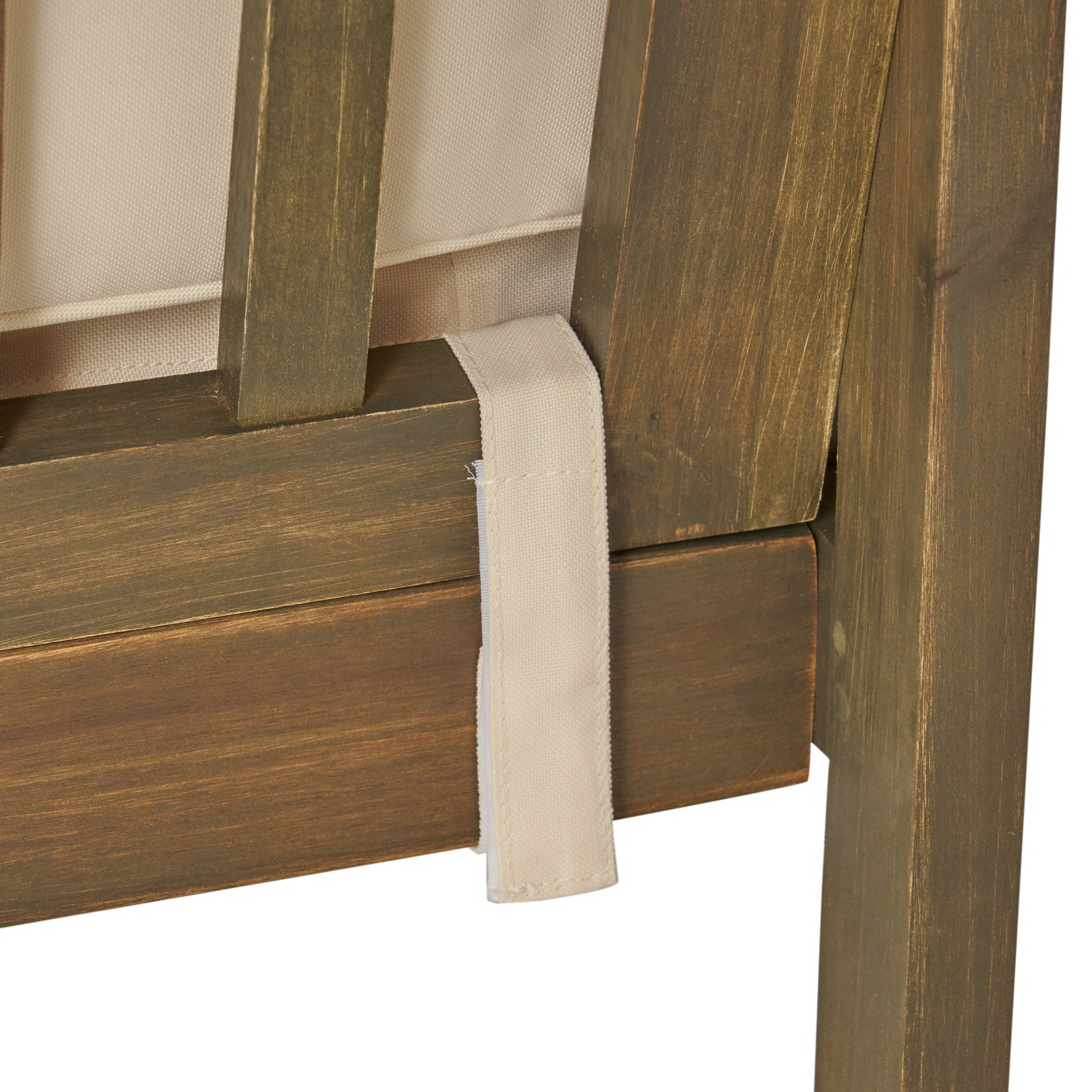 Dark wood frame detail with beige canvas strap on outdoor patio furniture