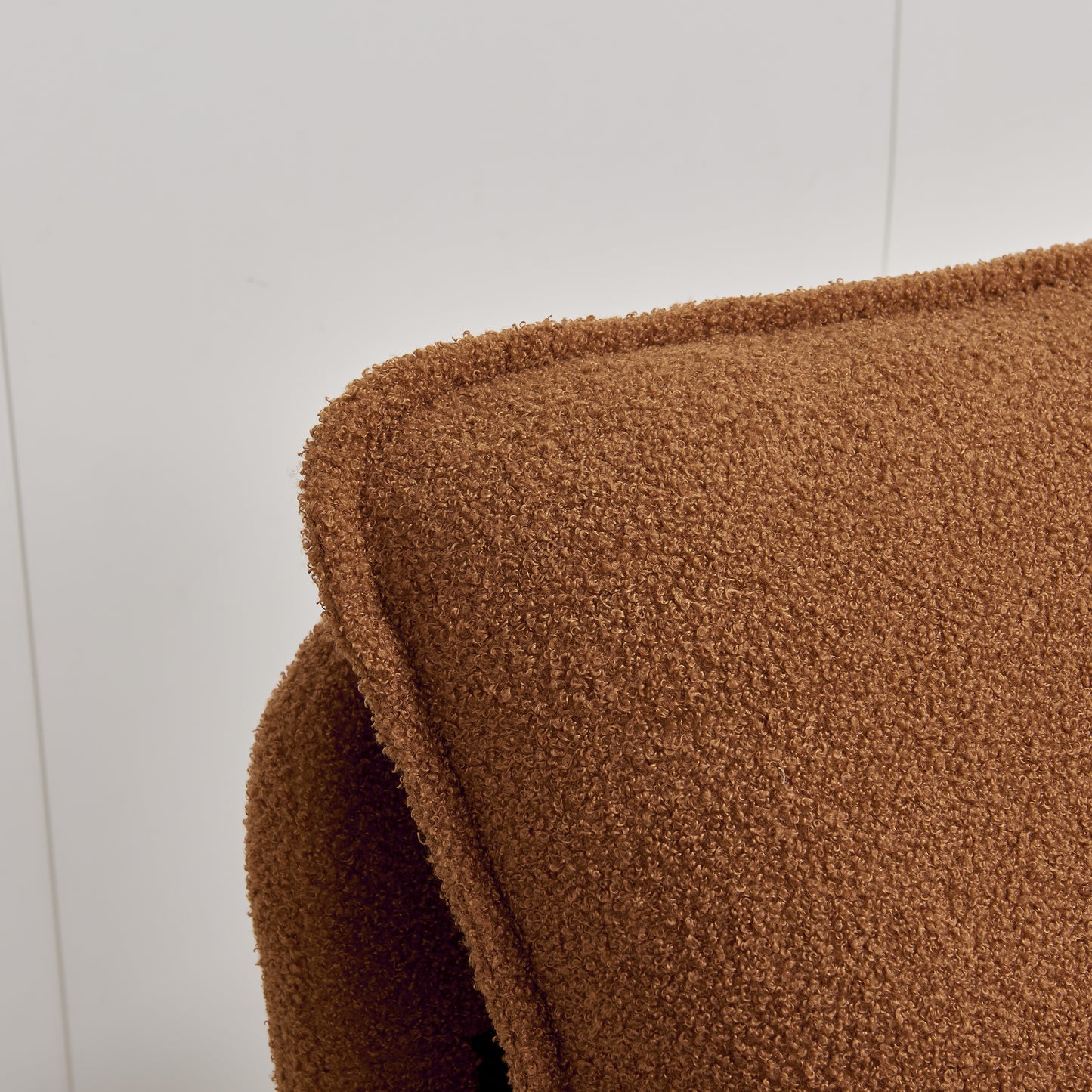 Closeup of a brown boucle fabric on a plush sofa cushion offering luxurious texture