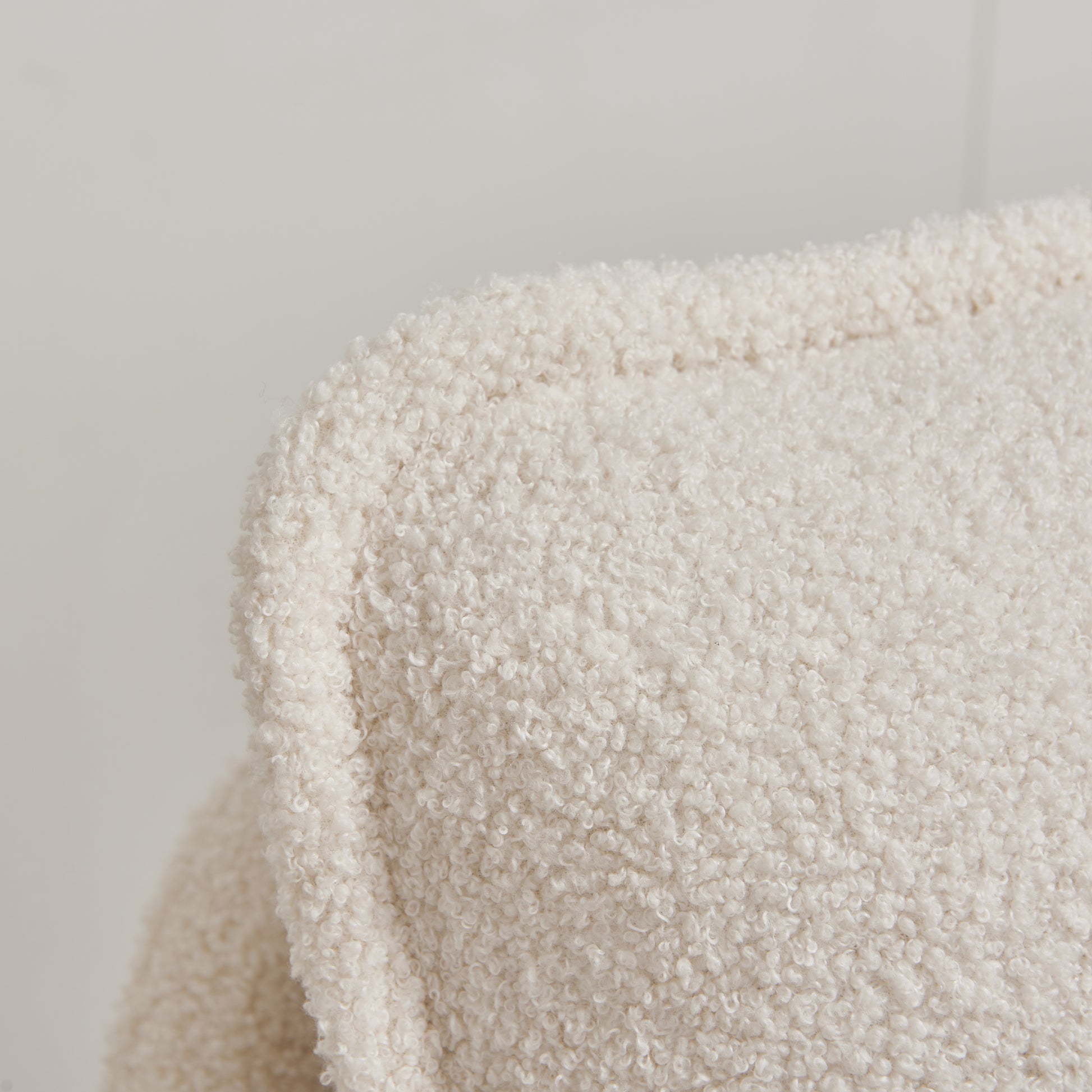 Close up of a cream boucle fabric texture on a chair cushion