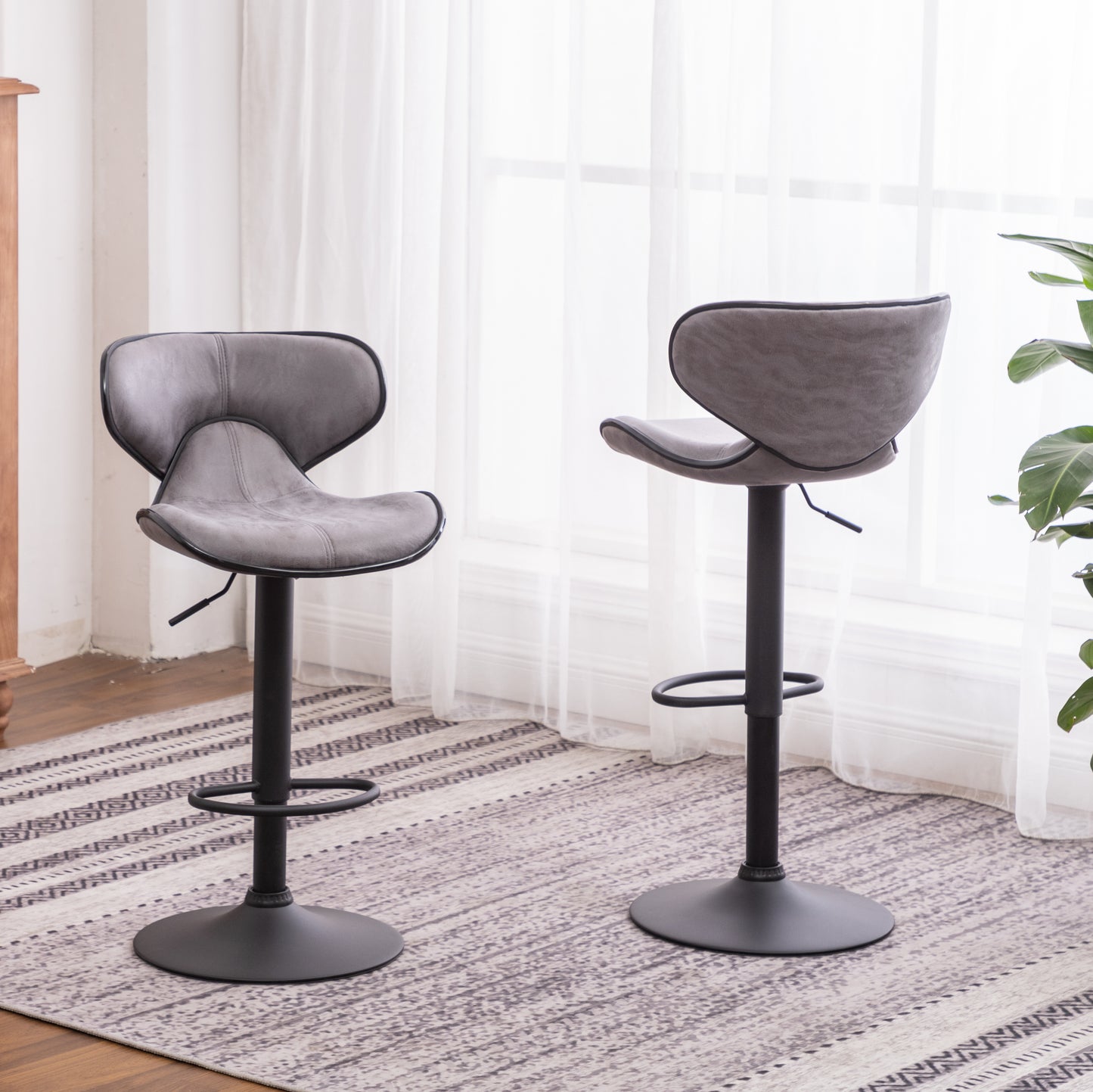Two grey faux leather bar stools with black trim and adjustable height