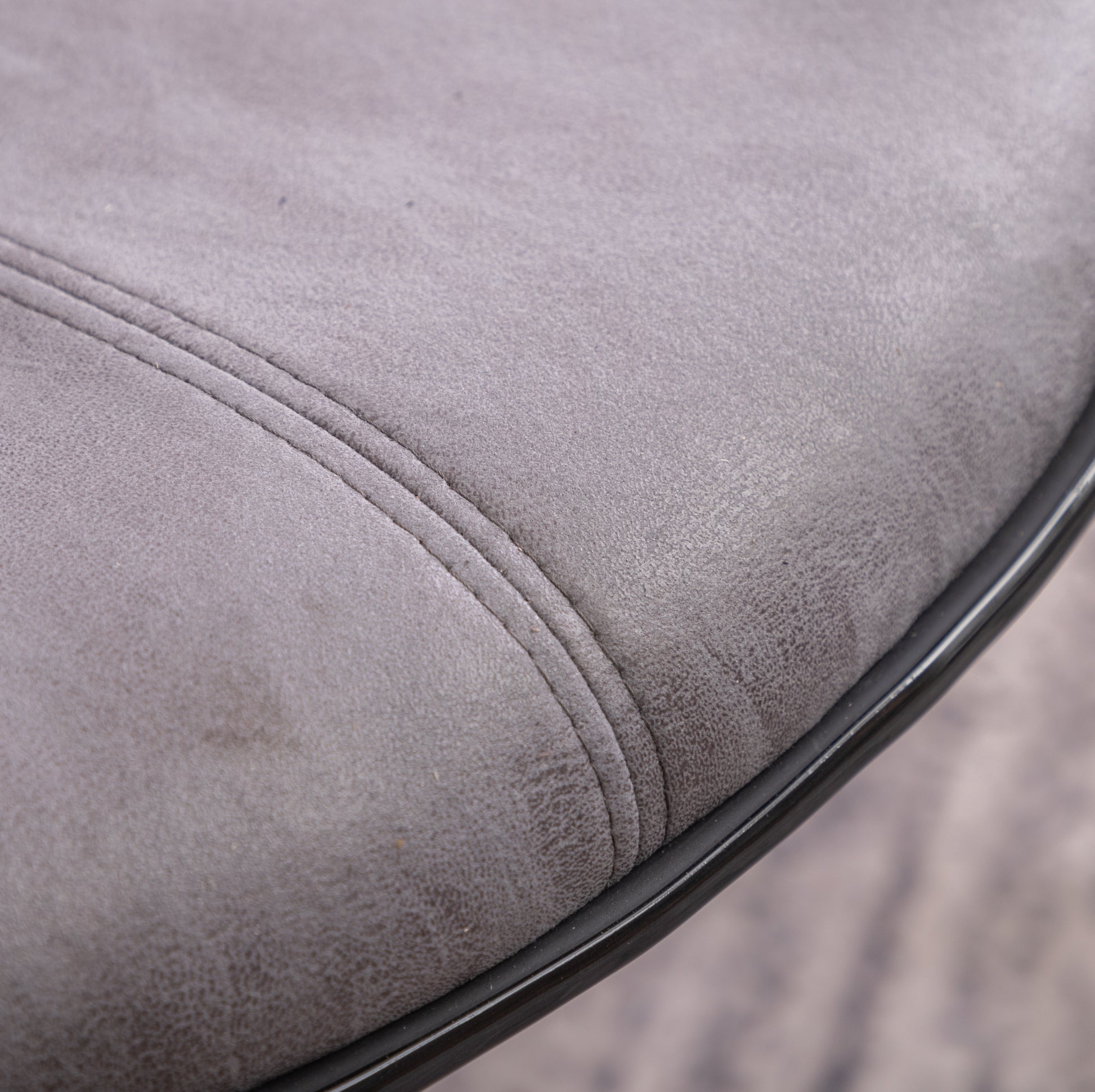 Closeup of a grey faux leather seat cushion with subtle stitching details