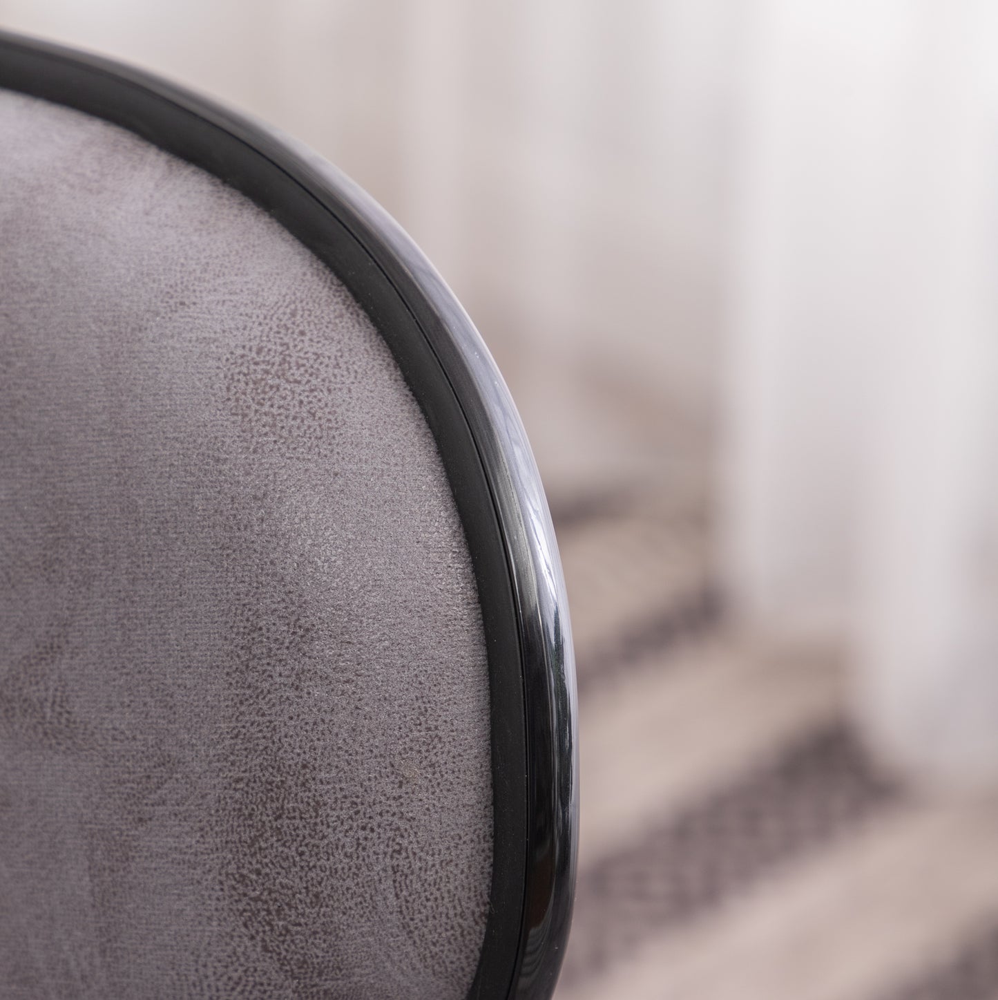 Closeup of textured gray fabric seat cushion with black trim suitable for office chairs