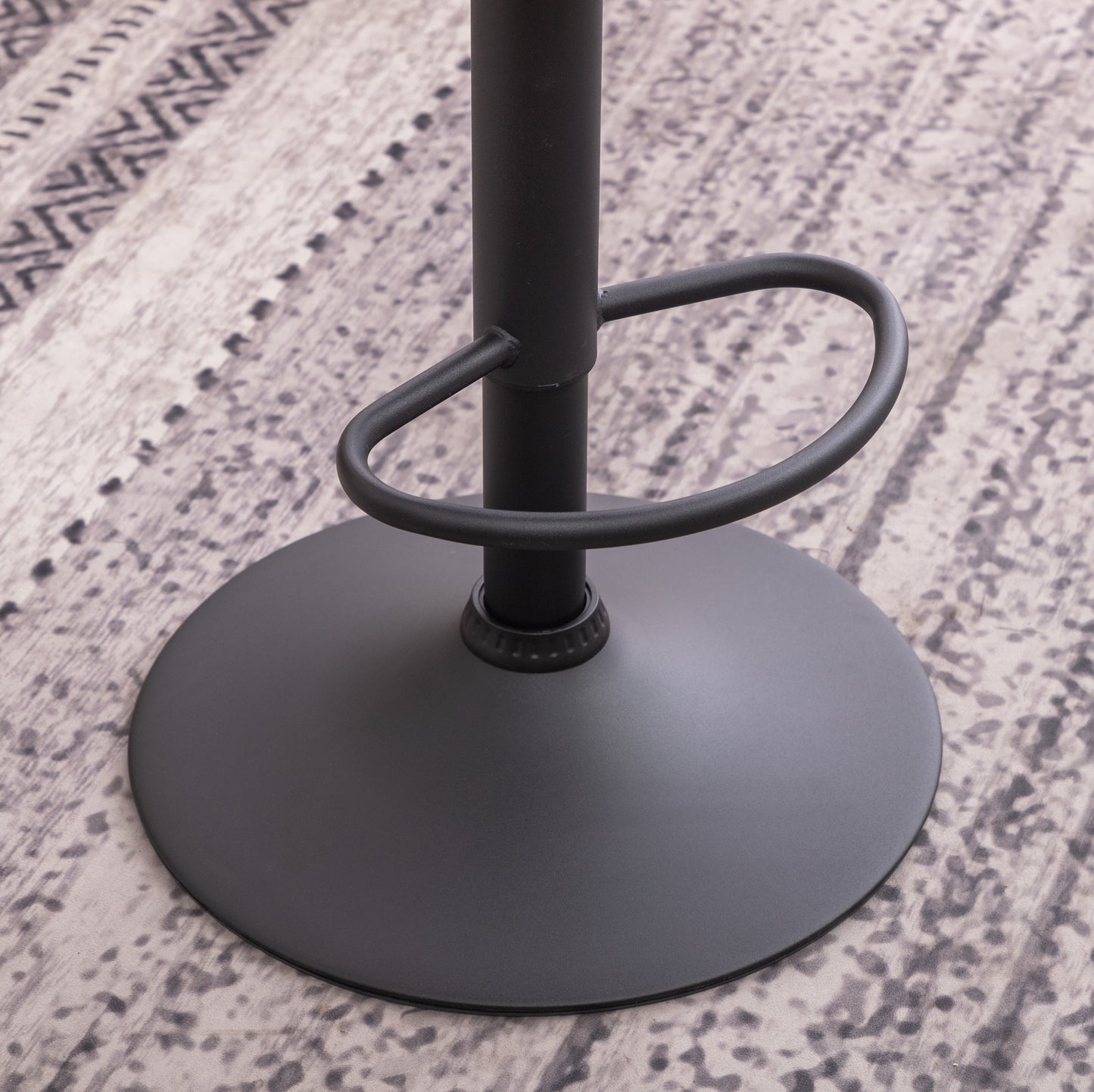 Black metal bar stool base with circular footrest on patterned rug