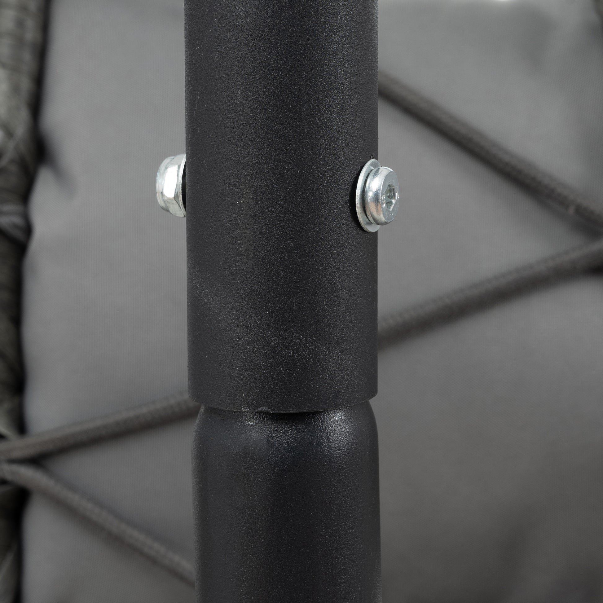 Closeup of a black metal frame with silver bolt detail on outdoor swing chair