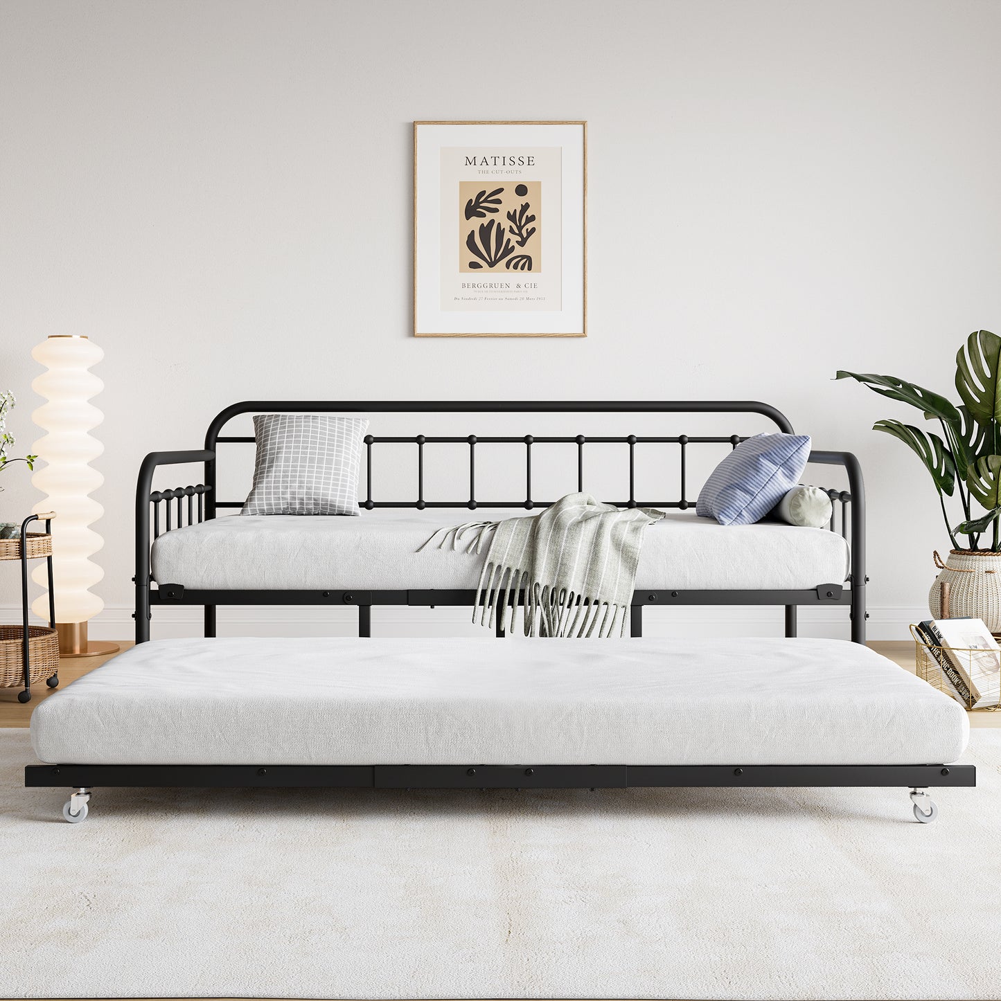 Black metal daybed with pullout trundle and white mattress perfect for guest rooms