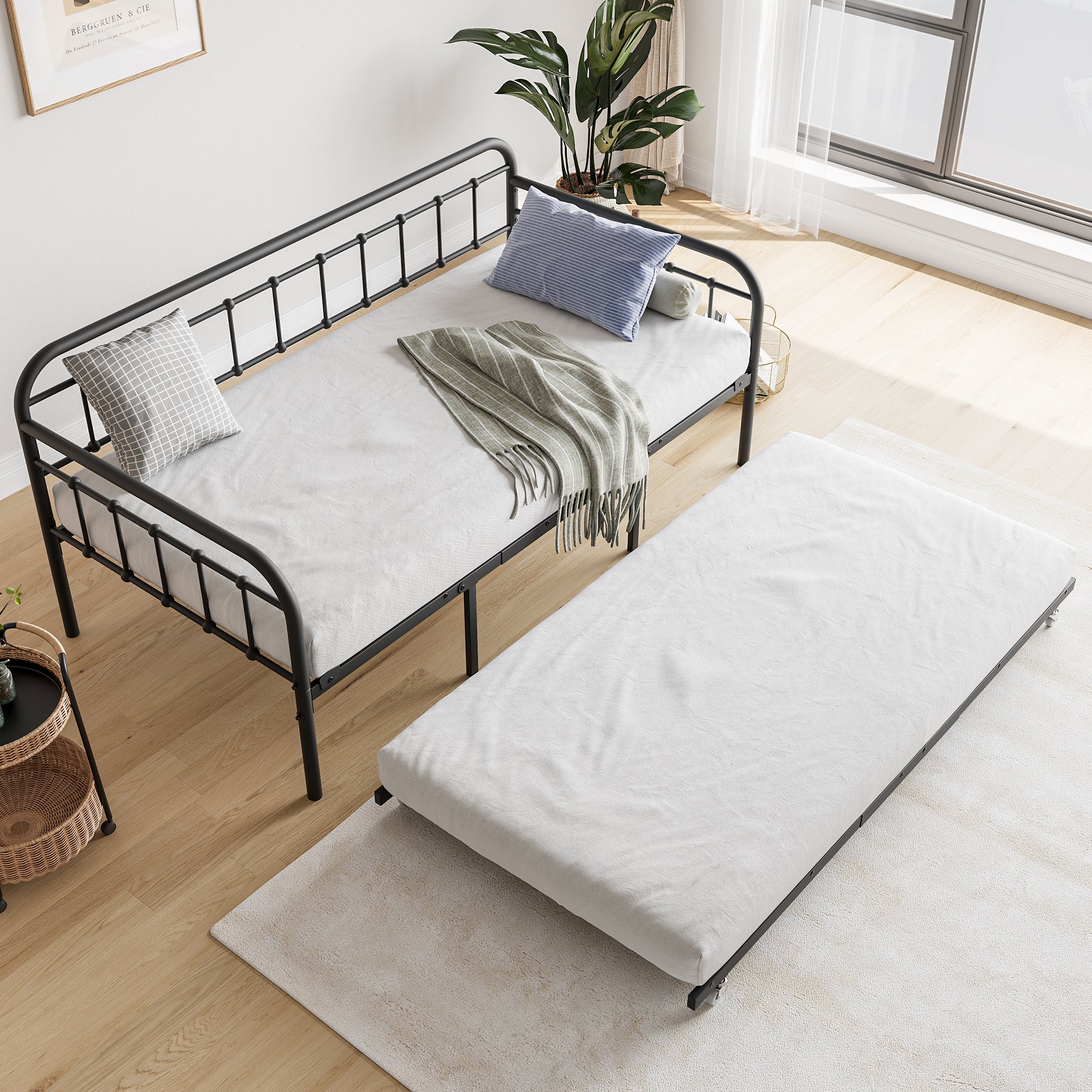 Black metal daybed with a gray patterned pillow and striped throw blanket