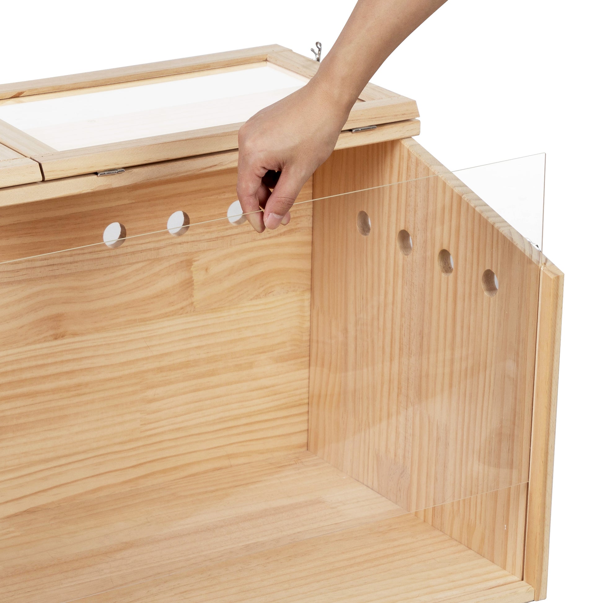 Closeup of a natural wood animal habitat showing ventilation holes and a clear acrylic panel